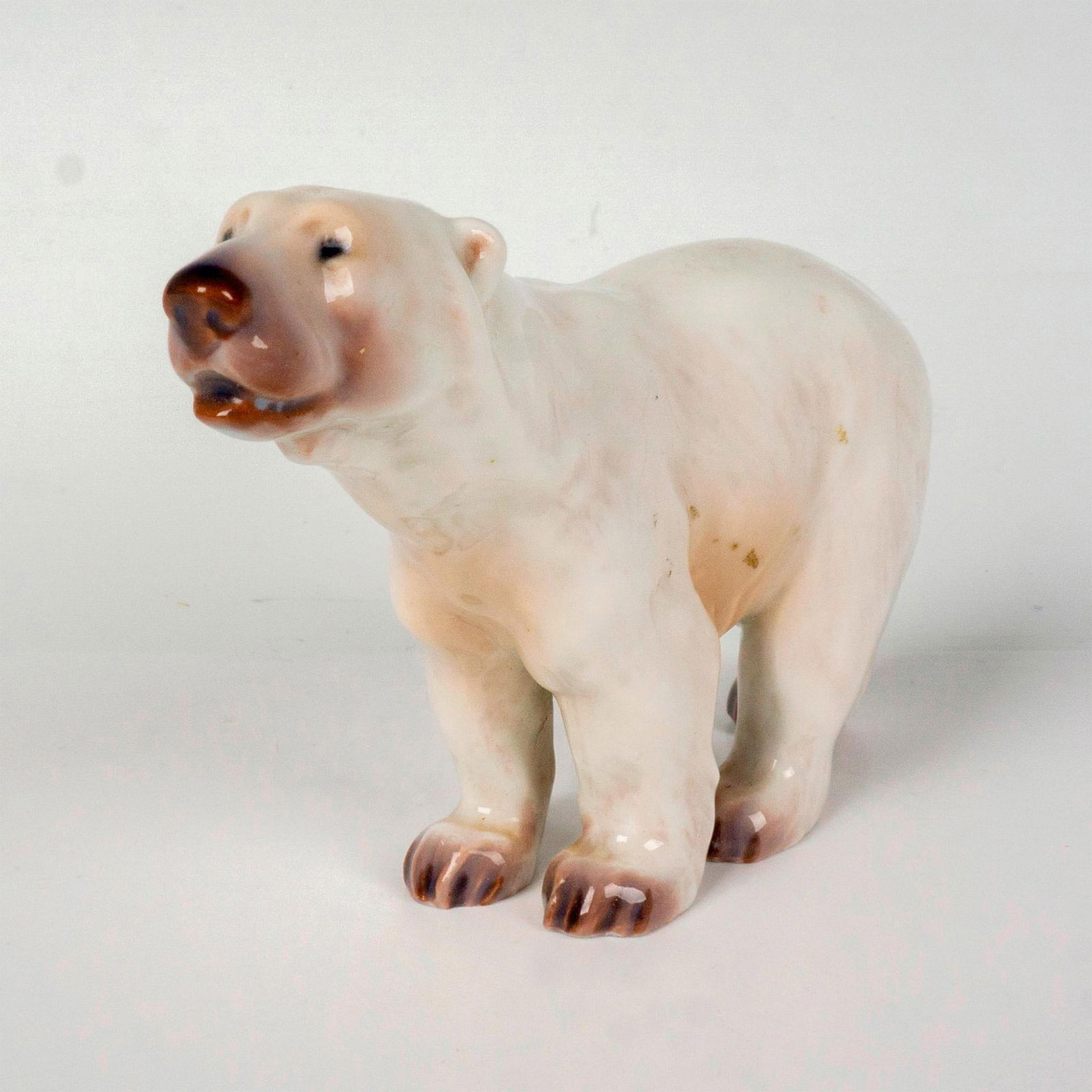 Dahl Jensen Figurine, Polar Bear: Features a hand painted polar bear standing. Model no. 1138. DJ Copenhagen Denmark backstamp. Dimensions: 1.25"L x 4.5"W x 3"H Manufacturer: Dahl Jensen DJ Copenhagen Country of Origin: Denmark