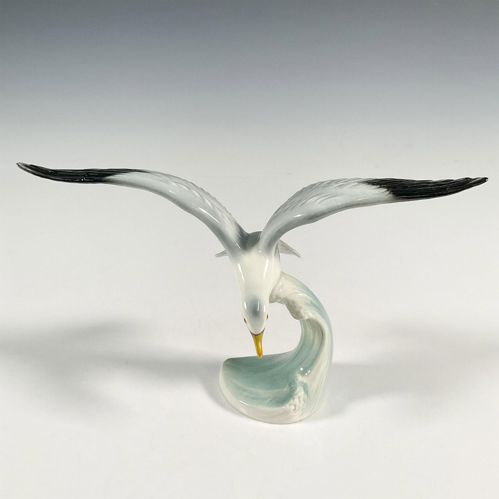 Goebel Porcelain Figurine, Silver Gull: A hand painted figure of a seagull over a wave. Goebel marked. Issued: 20th century Dimensions: 8.75"L x 3.75"W x 5"H Manufacturer: Goebel Country of Origin: Germany