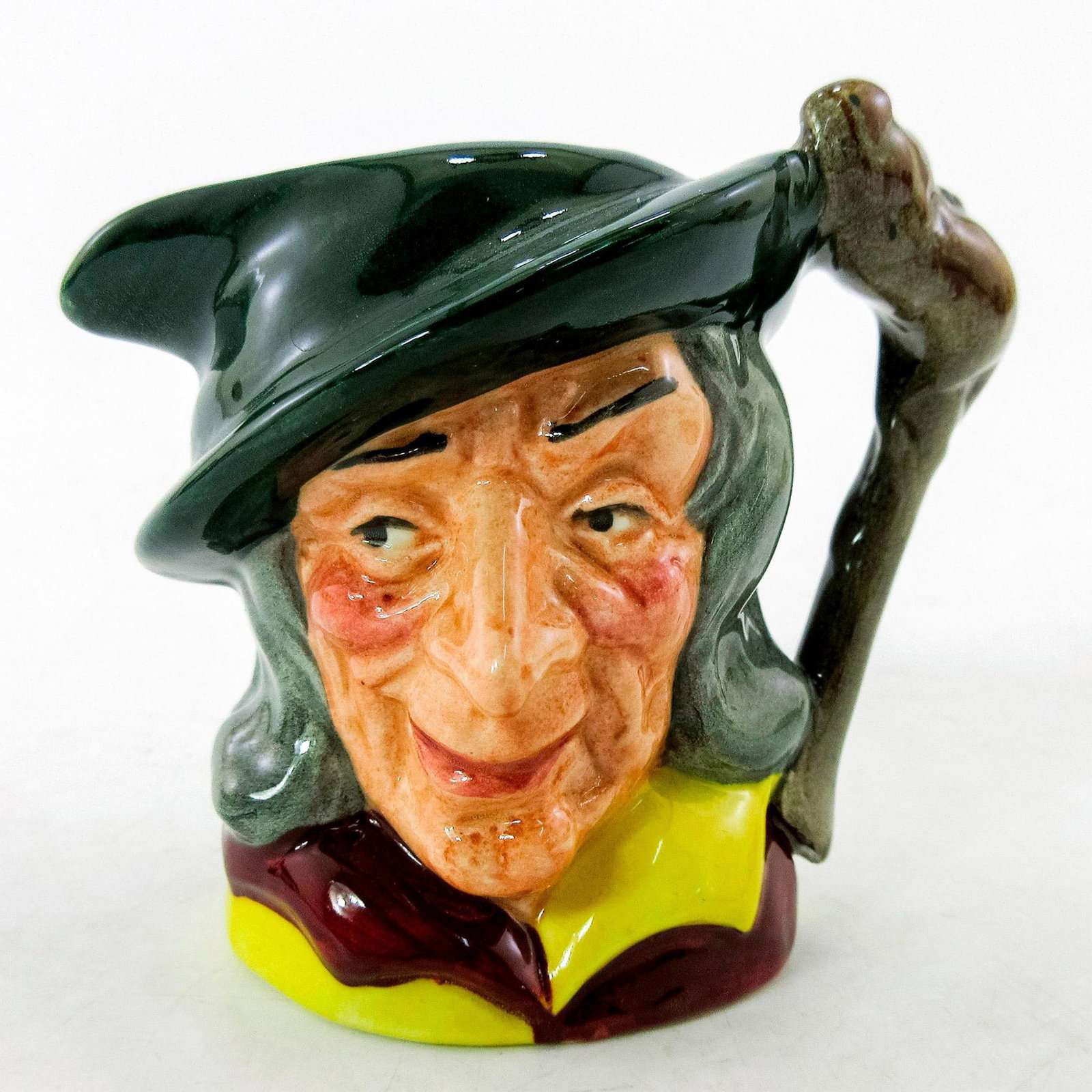 Pied Piper D6514 - Mini - Royal Doulton Character Jug: Green cap; maroon and yellow tunic; brown hair. In German legend, a stranger came to the town of Hamelin and told the mayor he would rid the village of rats for a sum of money. The Pied Piper walked t