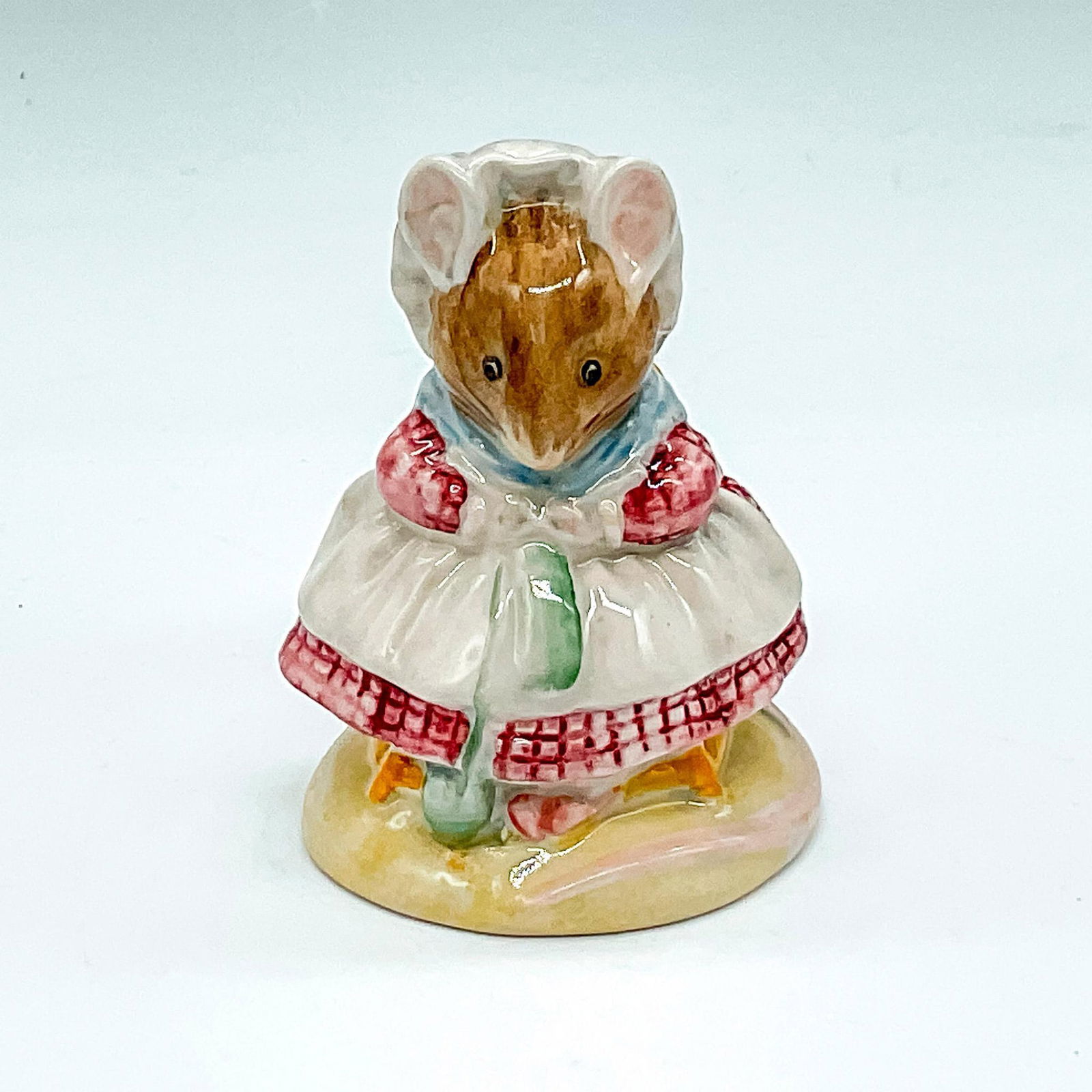 Beswick Beatrix Potter's Figurine, Old Woman Knitting: Soft coloration with pink edges and blue scarf. Beswick backstamp. Artist: David Lyttleton Issued: 1983 - 2002 Dimensions: 2.5"L x 2.5"W x 3.25"H Manufacturer: Beatrix Potter Country of Origin: E