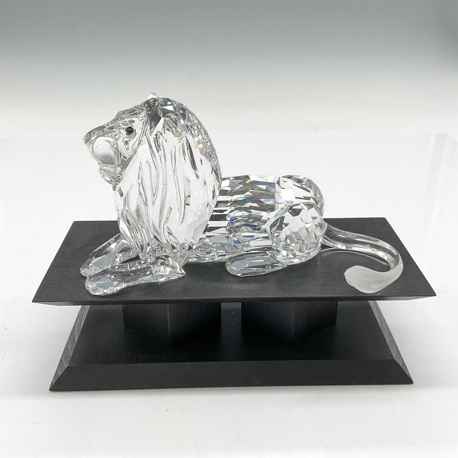 Swarovski SCS Crystal Figurine, Africa-Lion + Base: This 1995 Annual Edition was the last of the Inspiration Africa trilogy. Figural has clear crystal body with satin crystal tail and Sahara crystal eyes. Swarovski backstamp. 185410. This item has its 