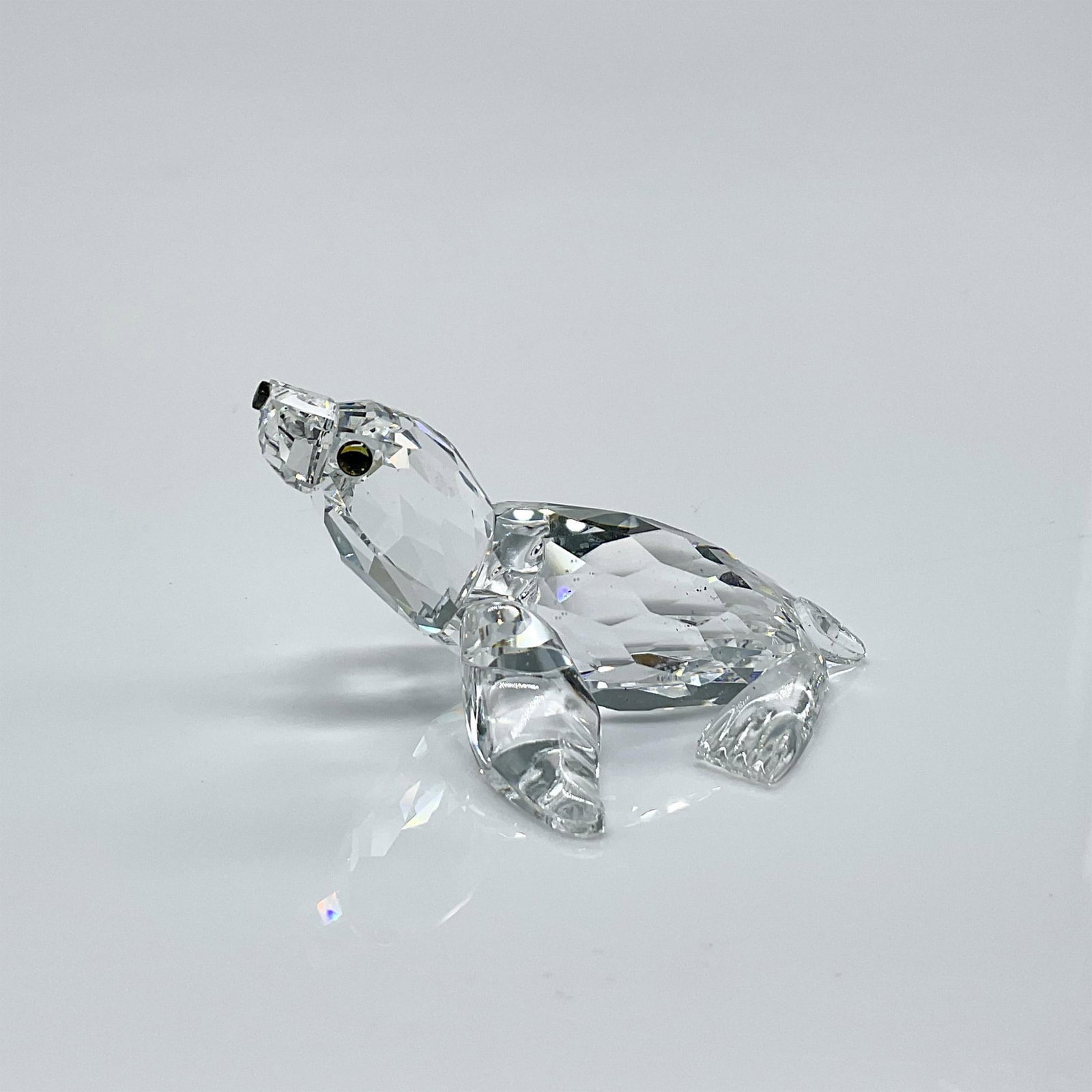 Swarovski Silver Crystal Figurine, Sea Lion: Clear faceted crystal figure of a sea lion with blue/green eyes, black nose. Part of the Aquatic Worlds collection. Swarovski mark. This item has its original box: 3.5"H x 3.25"dia. Issued: 1998-2010 