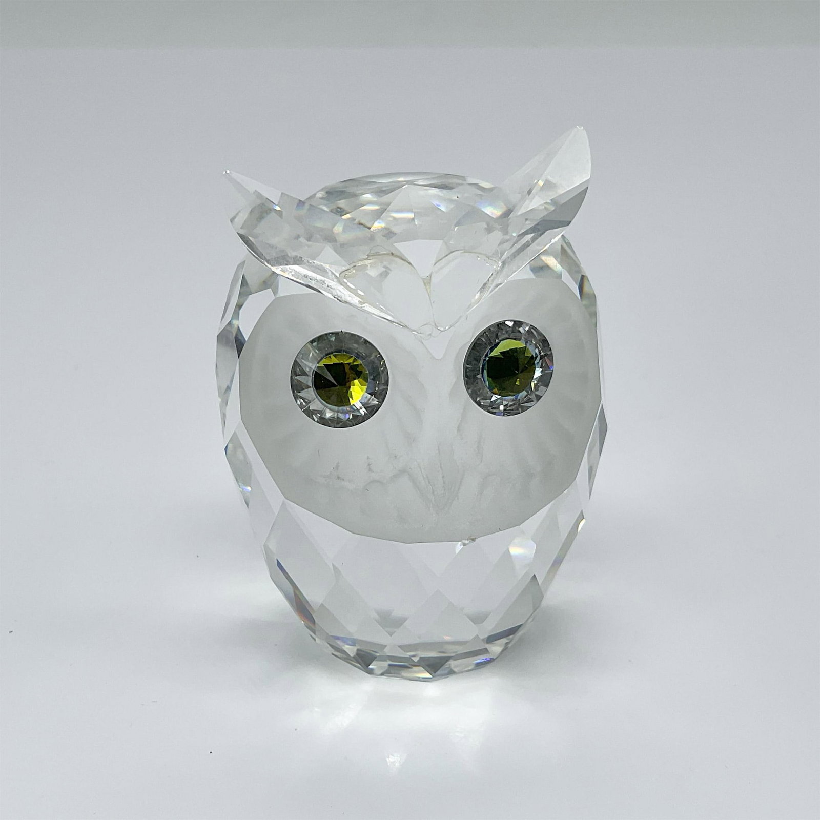 Swarovski Crystal Figurine, Owl: The owl has a clear crystal body, a frosted face, and Citron crystal eyes. Swarovski etched backstamp. Dimensions: 2"L x 2"W x 2.75"H Manufacturer: Swarovski Country of Origin: Austria