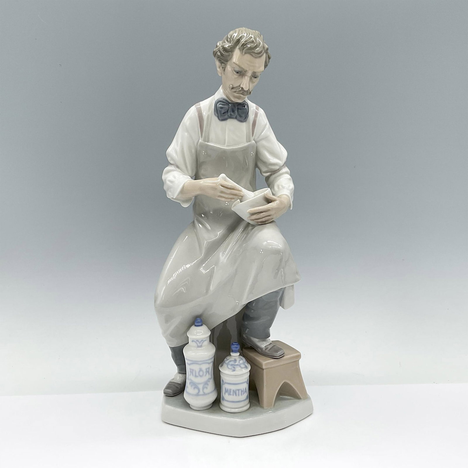 Lladro Porcelain Figurine Pharmacist 1004844: Beautiful figurine made with subtle colored hues and glossy finish. Lladro backstamp. Artist: Salvador Furio Issued: 1973-1985 Dimensions: 5.5"L x 5.5"W x 12.5"H Manufacturer: Lladro Country of Origi