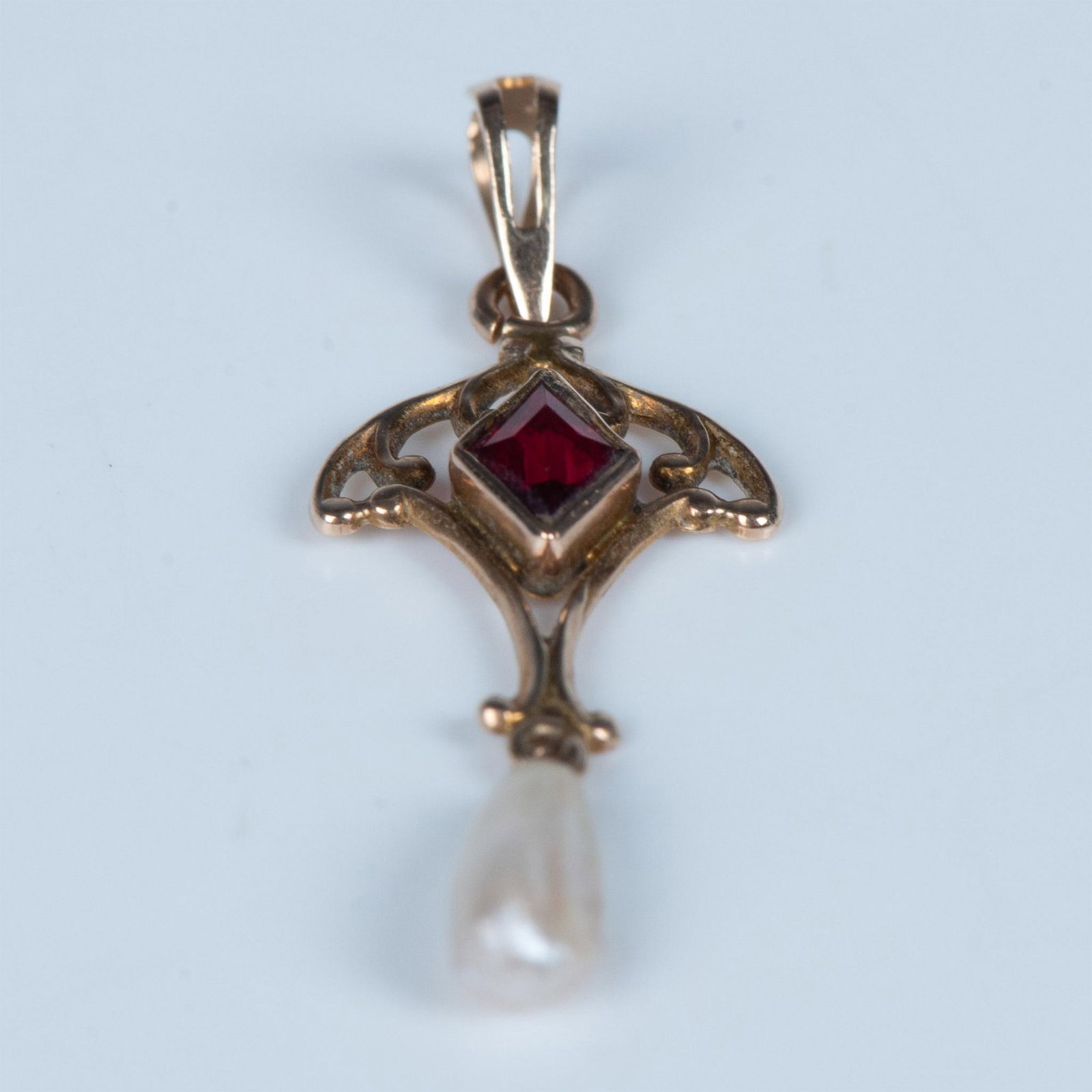 Vintage 18K Yellow Gold, Garnet & Pearl Pendant: This delicate pendant has a diamond-shaped garnet stone with a dangling baroque pearl. The metal tested as 18K gold. Dimensions: 1.25"L x 0.5"W