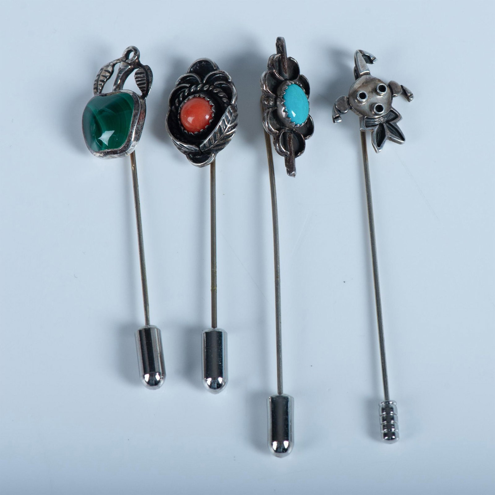4pc Sterling Silver Stick Pins: Great collection of fun and different sterling silver stick pins. Turquoise, malachite, and coral adorn three of the pins. The fourth pin is a unique sterling silver jester head. Issued: 20th century 