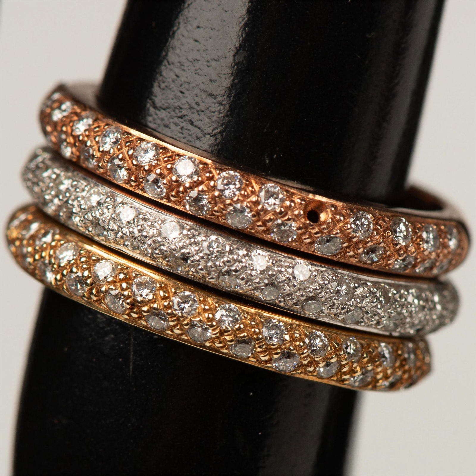 3pc Oro 14K Tri-Color Diamond Stackable Rings: Lovely classic stackable rings in rose, white and yellow gold. Two rows of pave diamonds adorn the front half of each band. The rose gold band is missing one stone. All rings backstamped 14K oro. Size