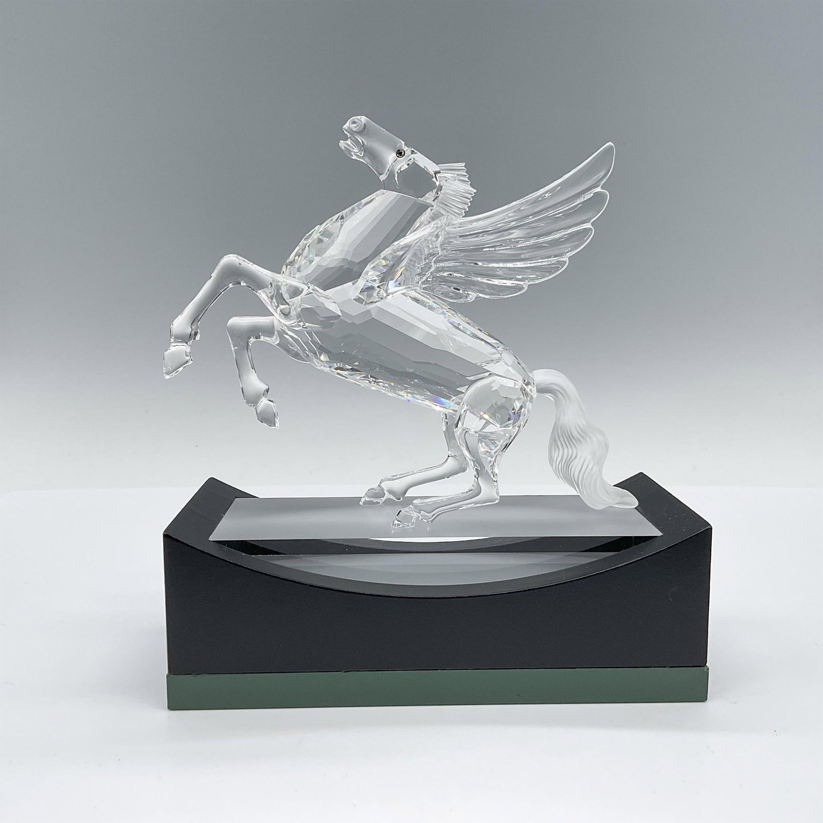 Swarovski Crystal Figurine, Pegasus with Base and Plaque: The concluding piece of the Fabulous Creatures trilogy, Pegasus stands proudly on its hind legs and tail. Crafted primarily from clear crystal, it features a matte crystal mane and tail, adorned with 