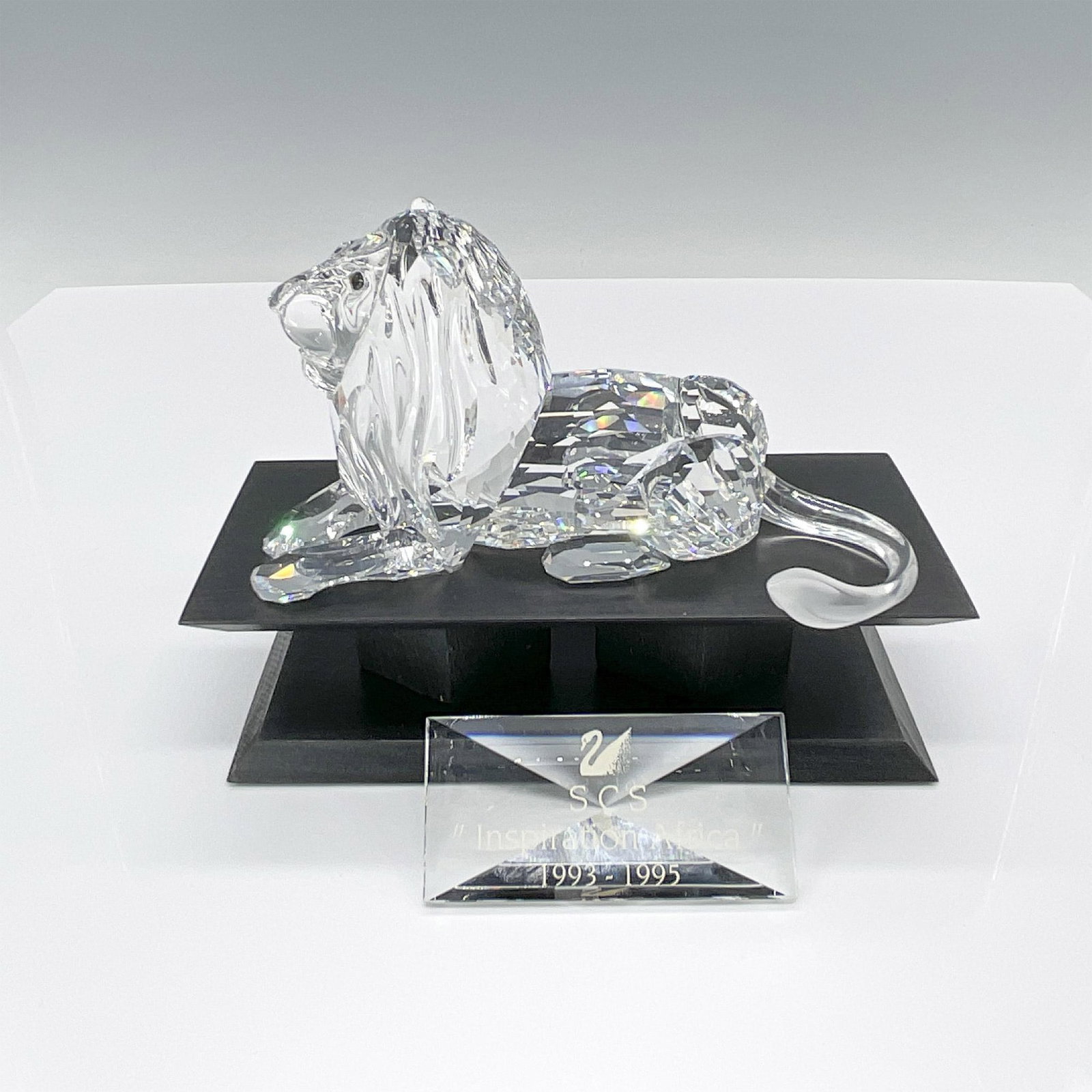 Swarovski Crystal Figurine, Lion with Base and Plaque: In honor of Swarovski's centenary year, the Lion marked the trilogy's finale. Crafted from clear crystal with frosted tail detailing, it includes a black wooden stand and a clear crystal plaque for th