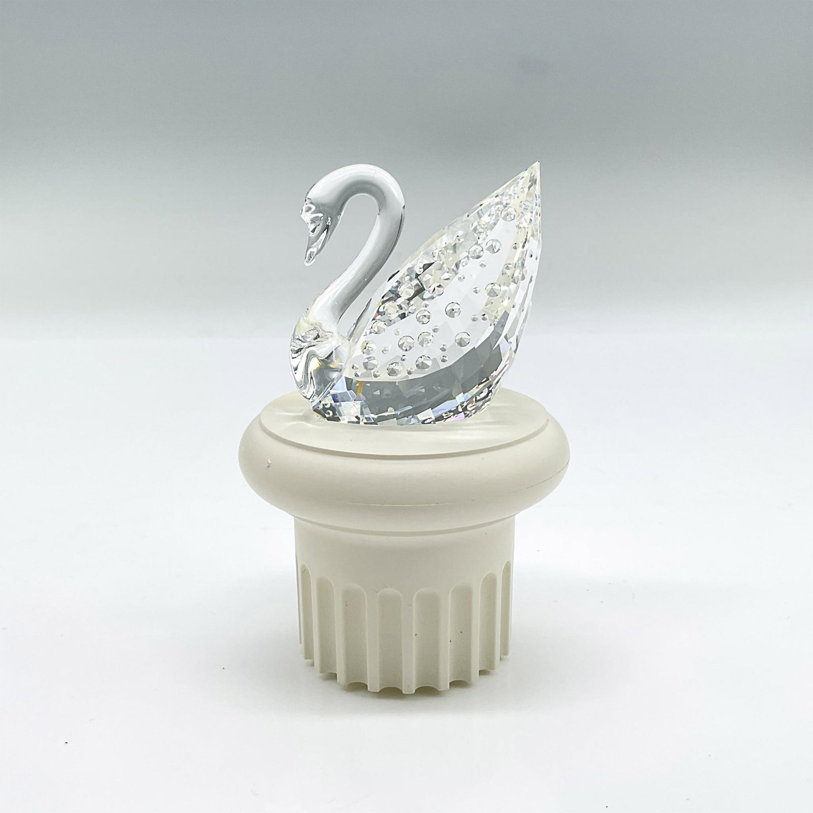 Swarovski Crystal Silver Figurine, Centennial Swan: Striking faceted crystal figure of the iconic swan with raised crystal accents, celebrating Swarovski's 100 year anniversary. Swarovski mark. Includes pillar stand: 2"H x 2.75"W. This item has its ori