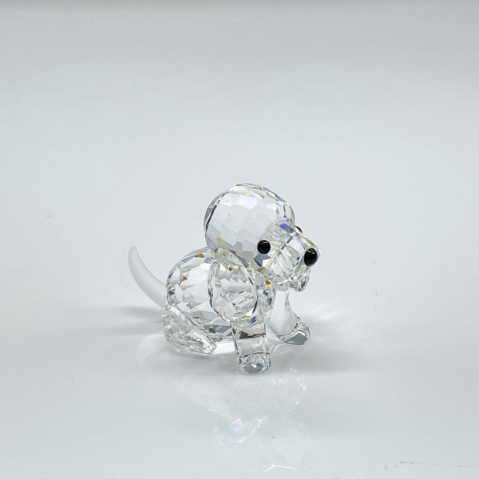 Swarovski Crystal Figurine, Beagle Puppy Sitting: Clear faceted crystal figure of a seated puppy with black eyes and nose, frosted tail. Swarovski etched mark. This item has its original box: 2.5"H x 3.25" diameter. Issued: 1990-2012 Dimensions: 1.5"