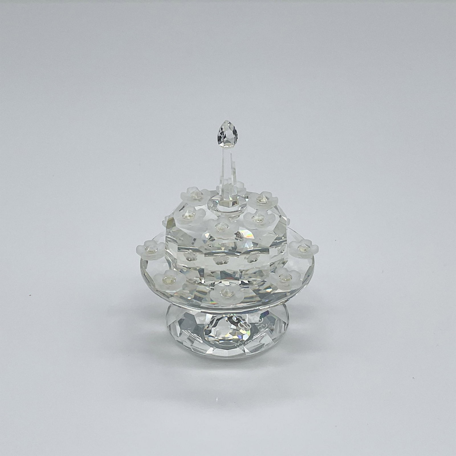 Swarovski SCS Crystal Figurine, Birthday Cake: This limited-edition birthday cake figurine was crafted exclusively for the SCS 5th anniversary celebration. The clear crystal cake, delicately placed on a stand, is adorned with frosted crystal flowe