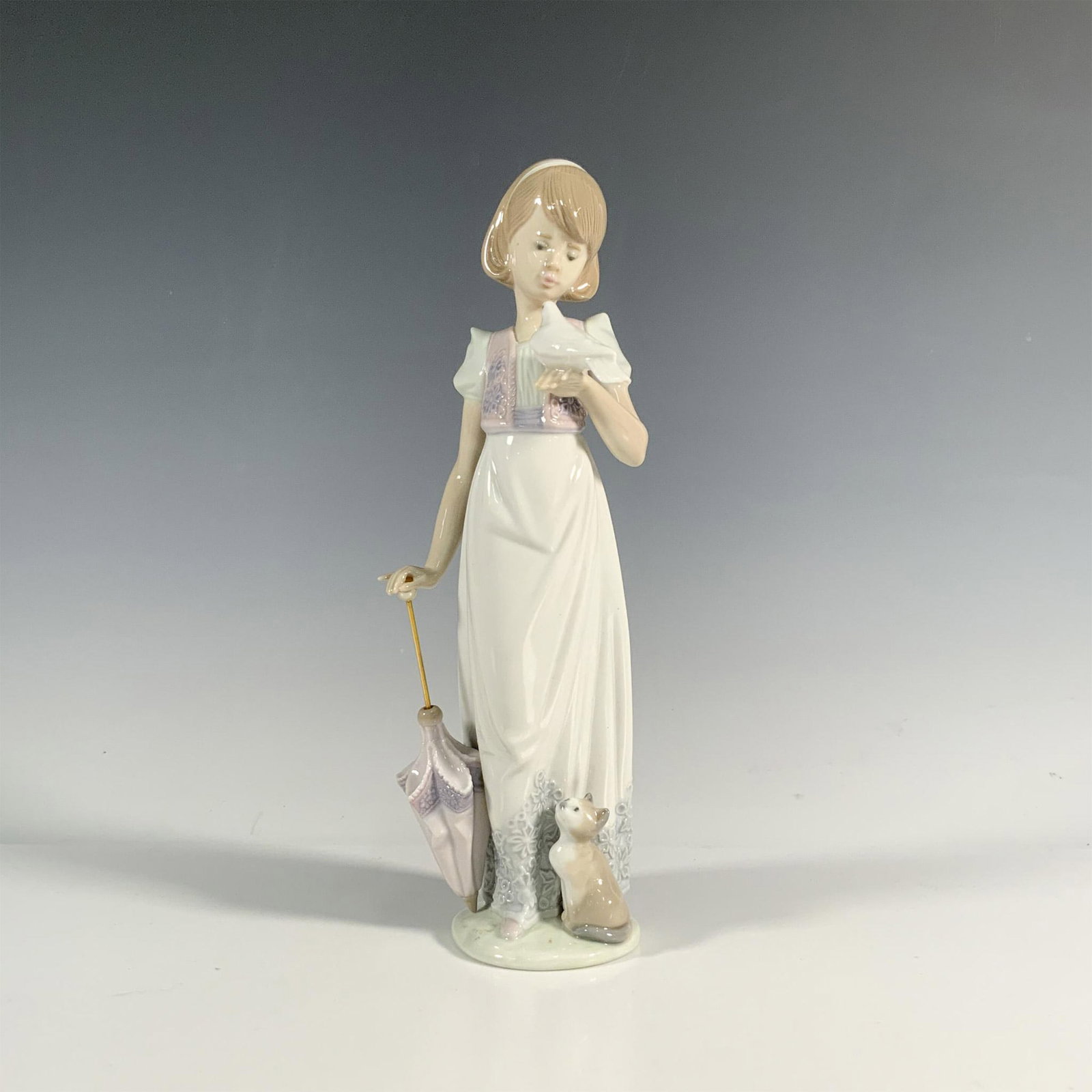 Summer Stroll 1007611 - Lladro Porcelain Figurine: Glossy finish; Lladro backstamp. Includes original box. Dimensions of the box: 10.75"L x 5.5"W x 5"H. Artist: Juan Huerta Issued: 1991 - 1991 Dimensions: 9.5"H x 3.25"W Manufacturer: Lladro Countr
