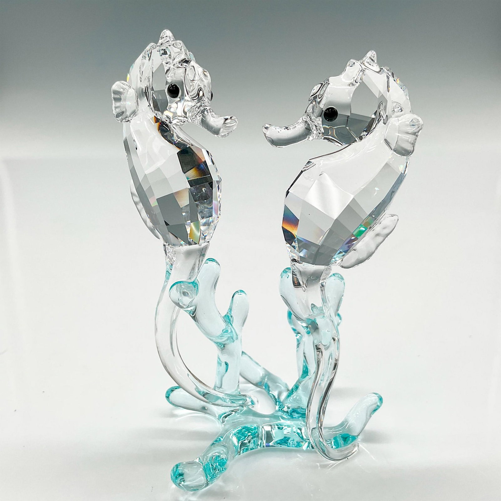 Swarovski Crystal Figurine, Seahorses: Part of the Aquatic Worlds collection. Clear faceted crystal bodies with jet crystal eyes balancing on smooth light azore crystal coral base. Swarovski backstamp. 9100 000 059. This item has its origi