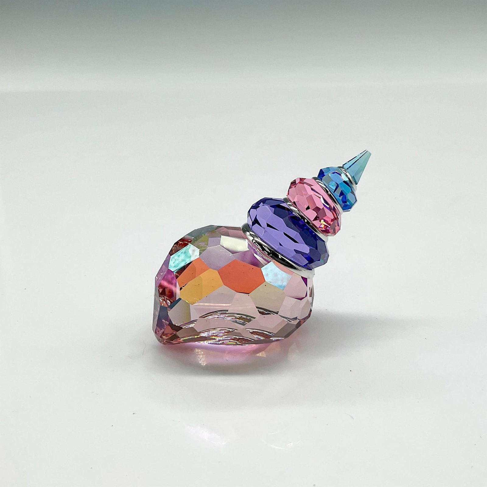 Swarovski Crystal Figurine, Blue Violet Corunna Shell: Part of the Exotic Fish collection this shell is colored in blue and violet crystal with a luster finish that catches the light. Swarovski backstamp. 9610 030 701. This item has its original box: 4.25