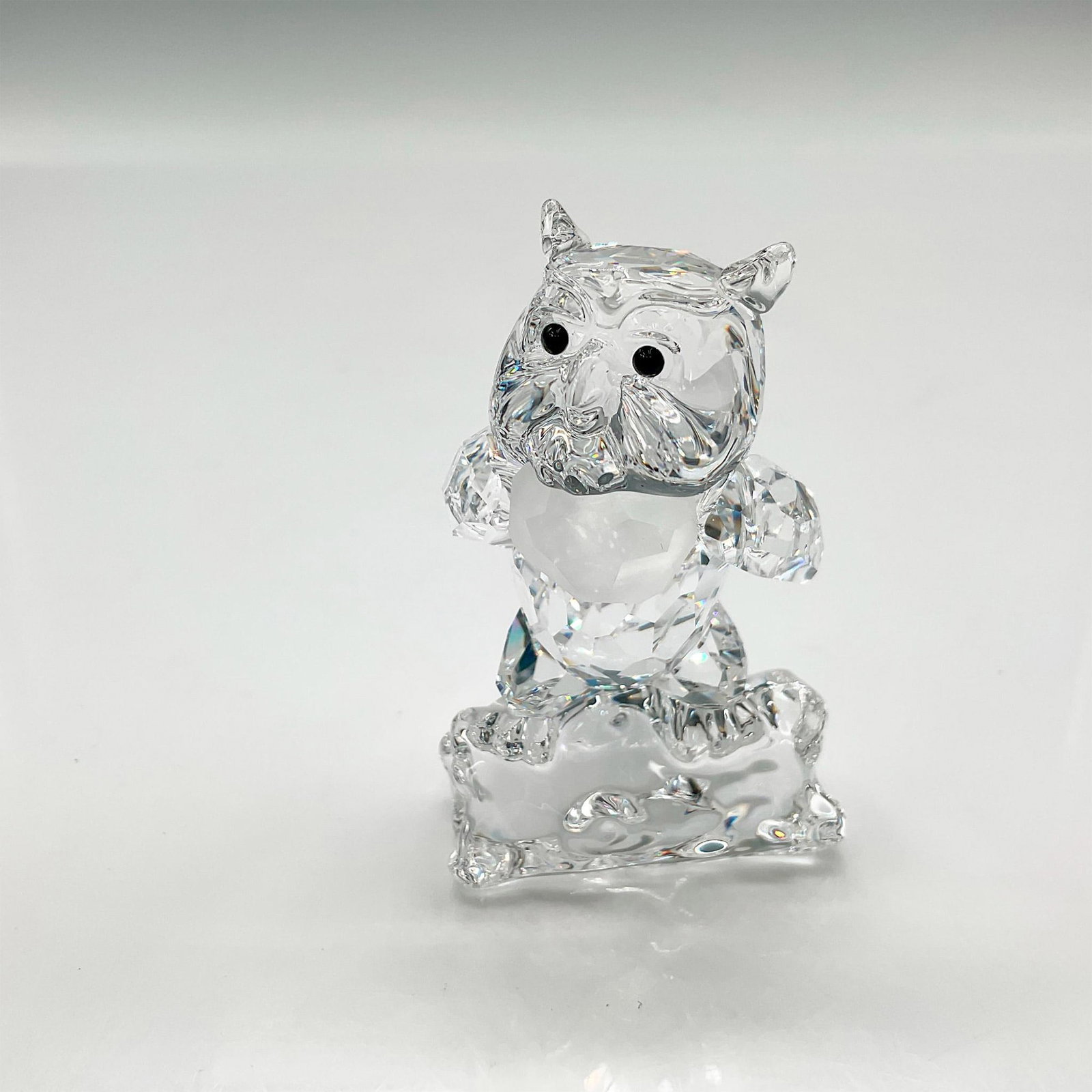Swarovski Silver Crystal Figurine, Friend Owl: Faceted owl with wings behind his back staring with jet crystal eyes with satin crystal scarf around his neck, perched on a log. Swarovski backstamp. 0943953. This item has its original box: 5"H x 3.2