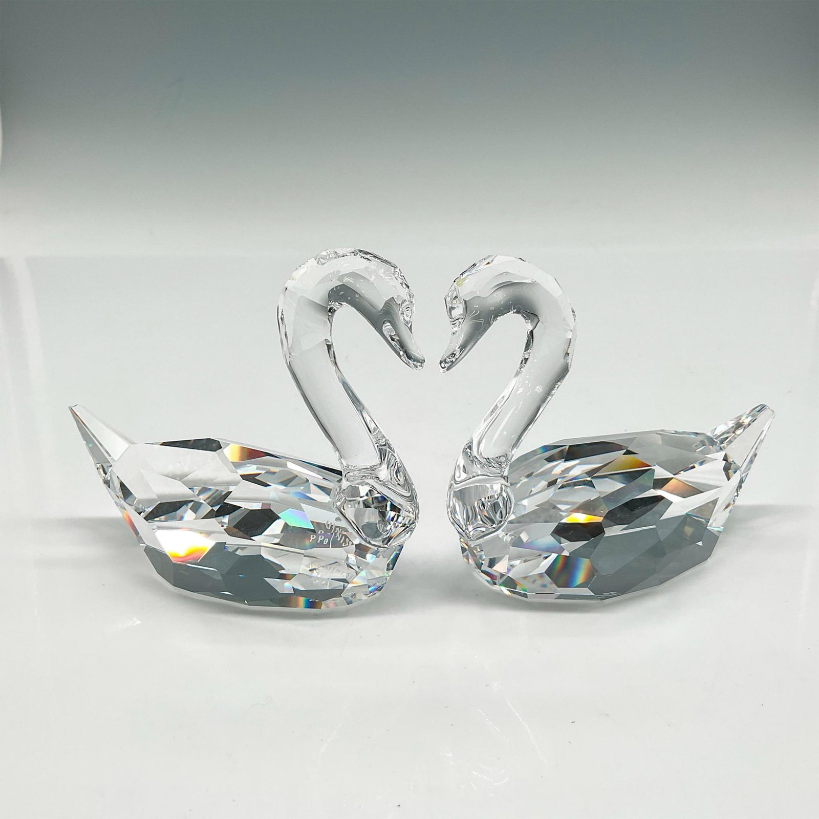 Swarovski Crystal Figurines, Signed, Flirting Swans: Part of the Feathered Beauties collection these swans were created with clear smooth crystal heads and necks with faceted bodies. Signed by artist. Swarovski backstamp. This item has its original box: