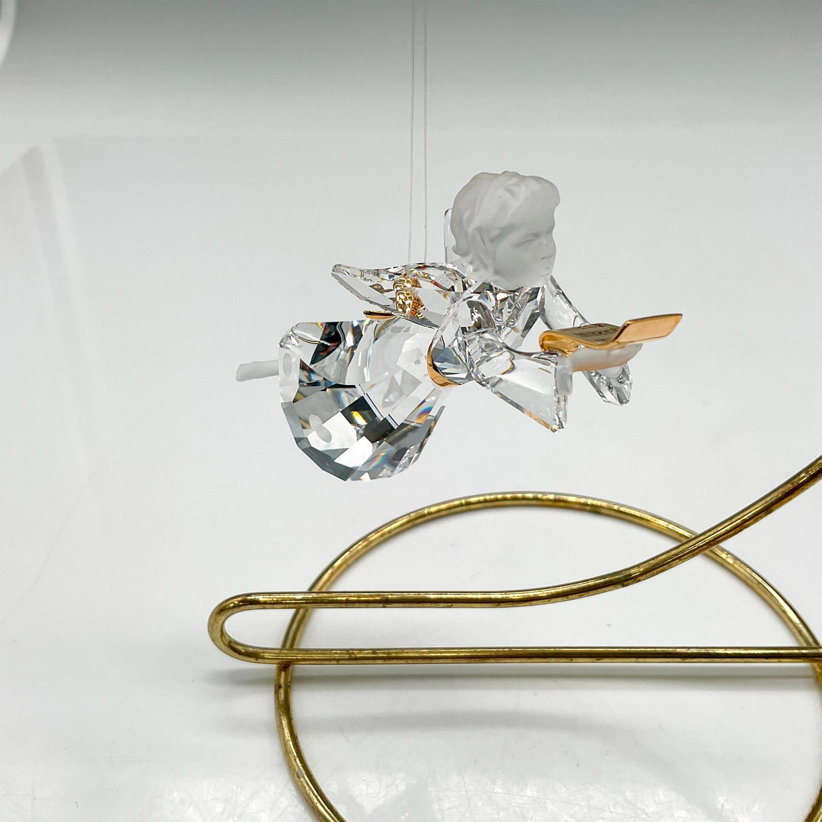Swarovski Crystal Ornament, Angel: This limited-edition ornament was created for 2007 only. Made of clear crystal body with satin crystal head, hands and feet holding a gold toned rhodium scroll. Swarovski impressed mark. 904989. This 