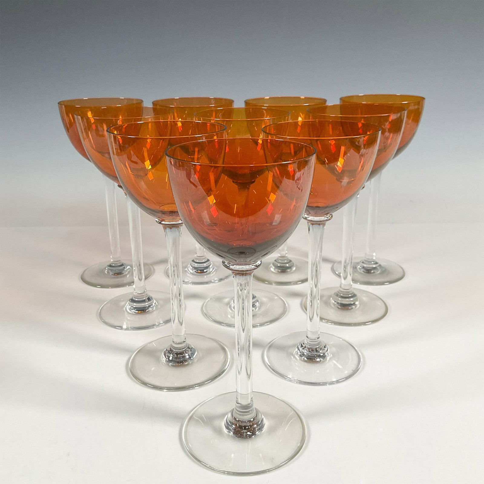 10pc Baccarat Rhine Wine Glasses, Amber: Each featuring an amber tone bowl and a clear stem and foot. Baccarat etched backstamp. Issued: 20th century Dimensions: 7.5"H x 3.25"dia Manufacturer: Baccarat Country of Origin: France