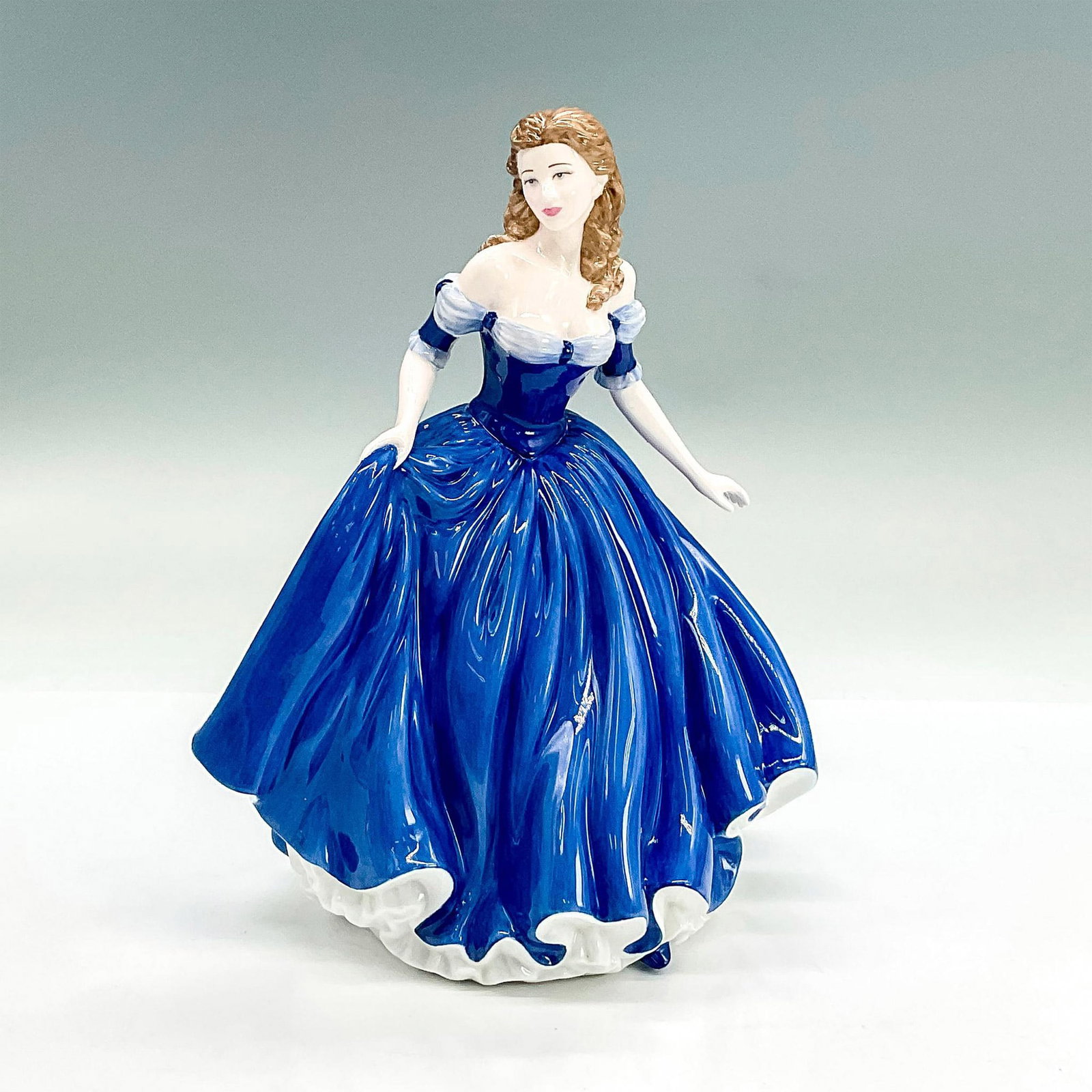 With Love - HN4746 - Royal Doulton Figurine: Glazed bone china figure of lady in an off-the-shoulder blue dress holding part of her skirt. Part of the Pretty Ladies series. Royal Doulton backstamp. Issued: 2004 Dimensions: 7"L x 5.25"W x 8.75"H 
