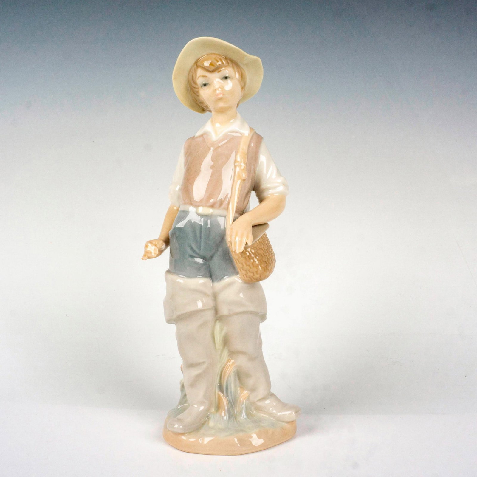 Going Fishing 1004809 - Lladro Porcelain Figurine: Glossy finish; Lladro backstamp. Artist: Salvador Furio Issued: 1972 - 2001 Dimensions: 8.5"H x 3.25"W Manufacturer: Lladro Country of Origin: Spain