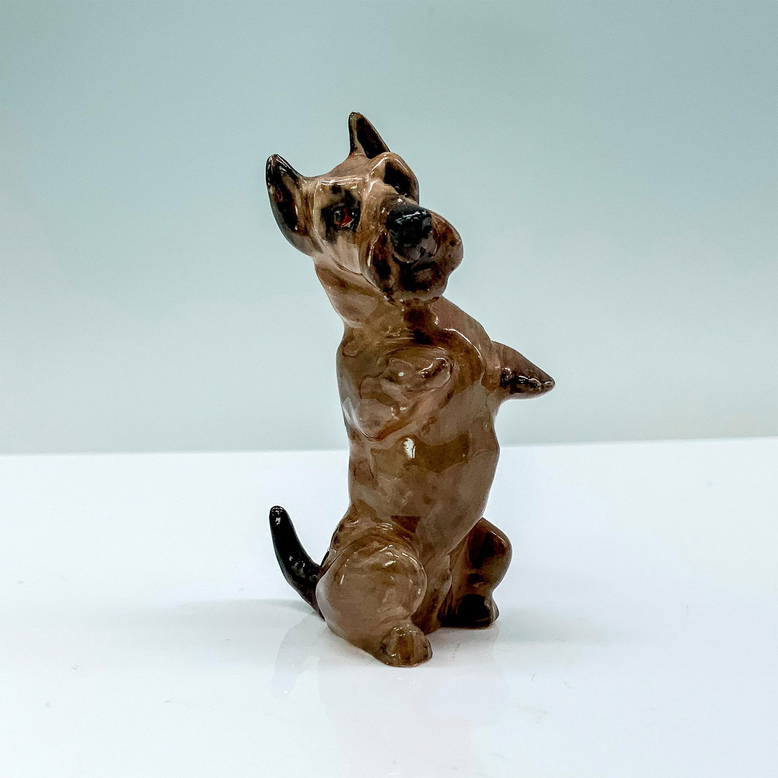 Royal Doulton Dog Figurine, Scottish Terrier K10: A porcelain Scottish Terrier that has gray fur with some darker accents that is sitting upright. Royal Doulton backstamp. Issued: 1931-1977 Dimensions: 1.5"L x 1"W x 2.75"H Manufacturer: Royal Doulton