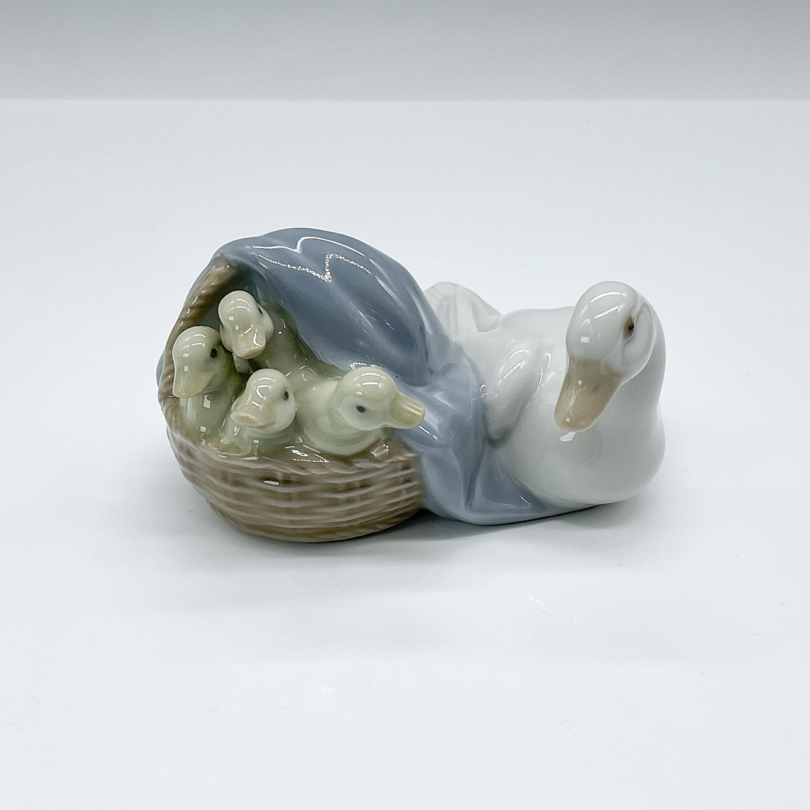 Ducks 1004895 - Lladro Porcelain Figurine: Glossy finish; Lladro backstamp. Artist: Juan Huerta Issued: 1974 Dimensions: 2.25"H x 3.5"W Manufacturer: Lladro Country of Origin: Spain