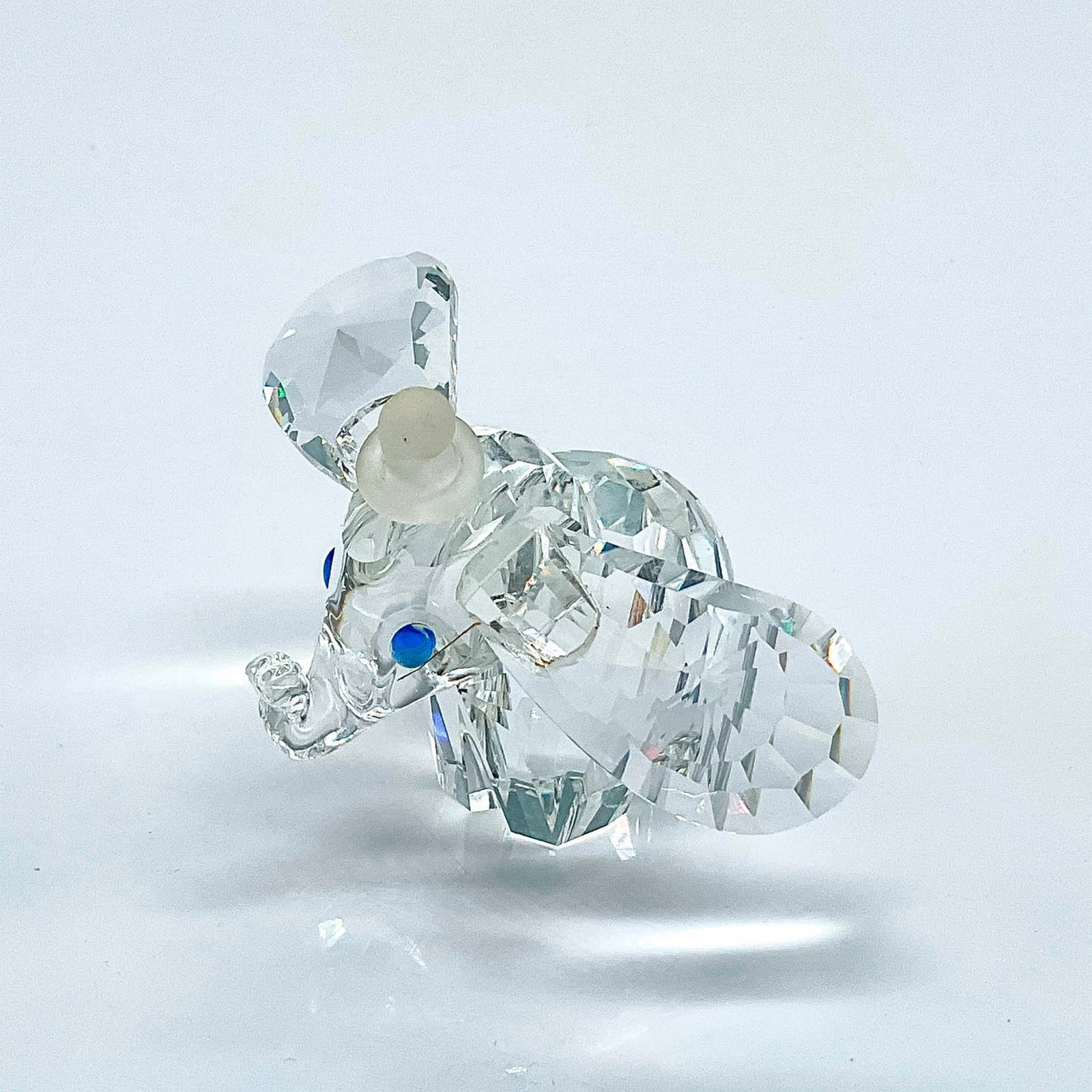 Swarovski Crystal Figurine, Dumbo: Multifaceted clear crystal Dumbo frosted hat and tail, and blue eyes. Originally only available in Disney Theme Parks. Number 7640NR100001. Swarovski and Disney etched backstamp. This item has its ori