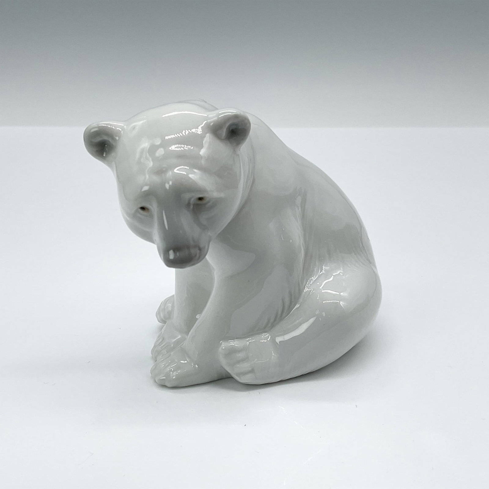 Seated Polar Bear 1001209 - Lladro Porcelain Figurine: Glossy finish; Lladro backstamp. Artist: Juan Huerta Issued: 1972 - 1992 Dimensions: 3.5"H x 3.25"W Manufacturer: Lladro Country of Origin: Spain
