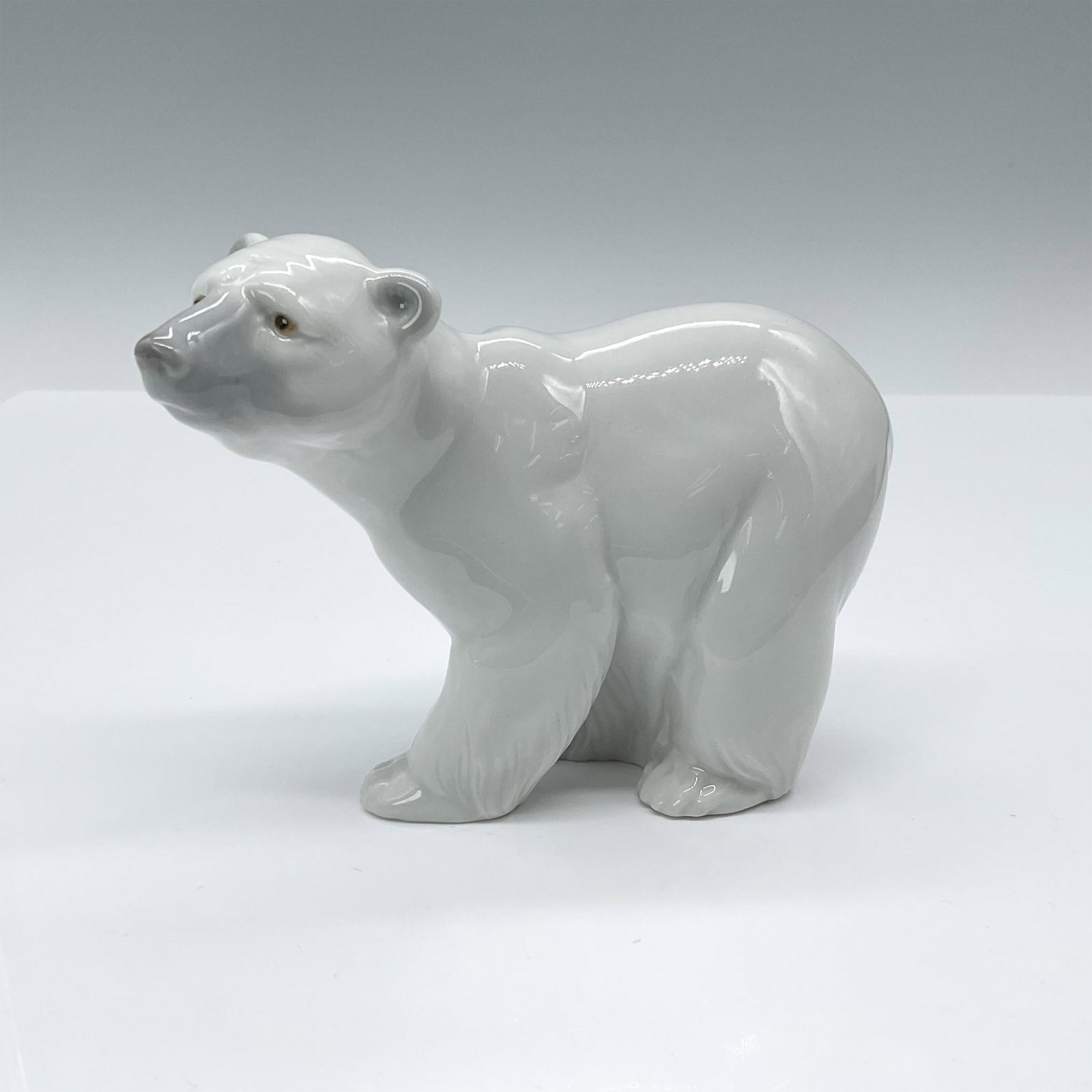 Attentive Polar Bear 1001207 - Lladro Porcelain Figurine: Glossy finish; Lladro backstamp. Artist: Juan Huerta Issued: 1972 Dimensions: 4"H x 5"W Manufacturer: Lladro Country of Origin: Spain