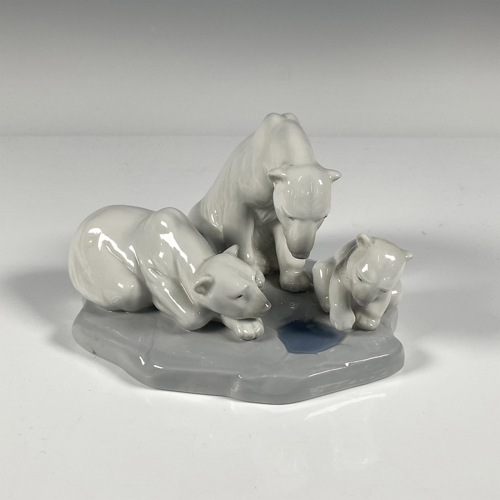 Lladro Porcelain Figurine, Bearly Love 1001443: Hand painted porcelain figurine of 3 polar bears at a hole in the ice. Gloss finish. Impress mark 1443. Lladro backstamp in blue. Issued: 20th century Dimensions: 6.25"L x 5.25"W x 3.75"H Manufacturer