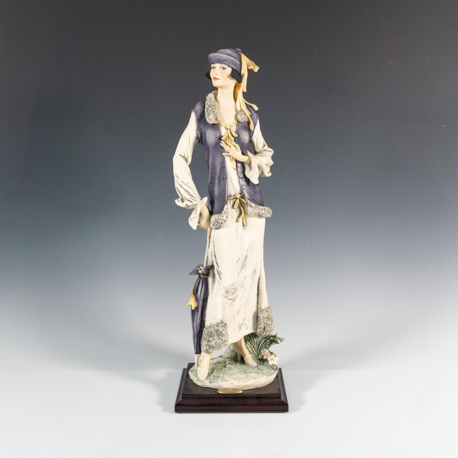 Florence Giuseppe Armani Figurine, Tamara: Limited edition figure of an elegant lady in a long white dress, and a purple cardigan vest and matching umbrella and hat. Giuseppe Armani plaque on the front of the base. Florence Giuseppe Armani mar