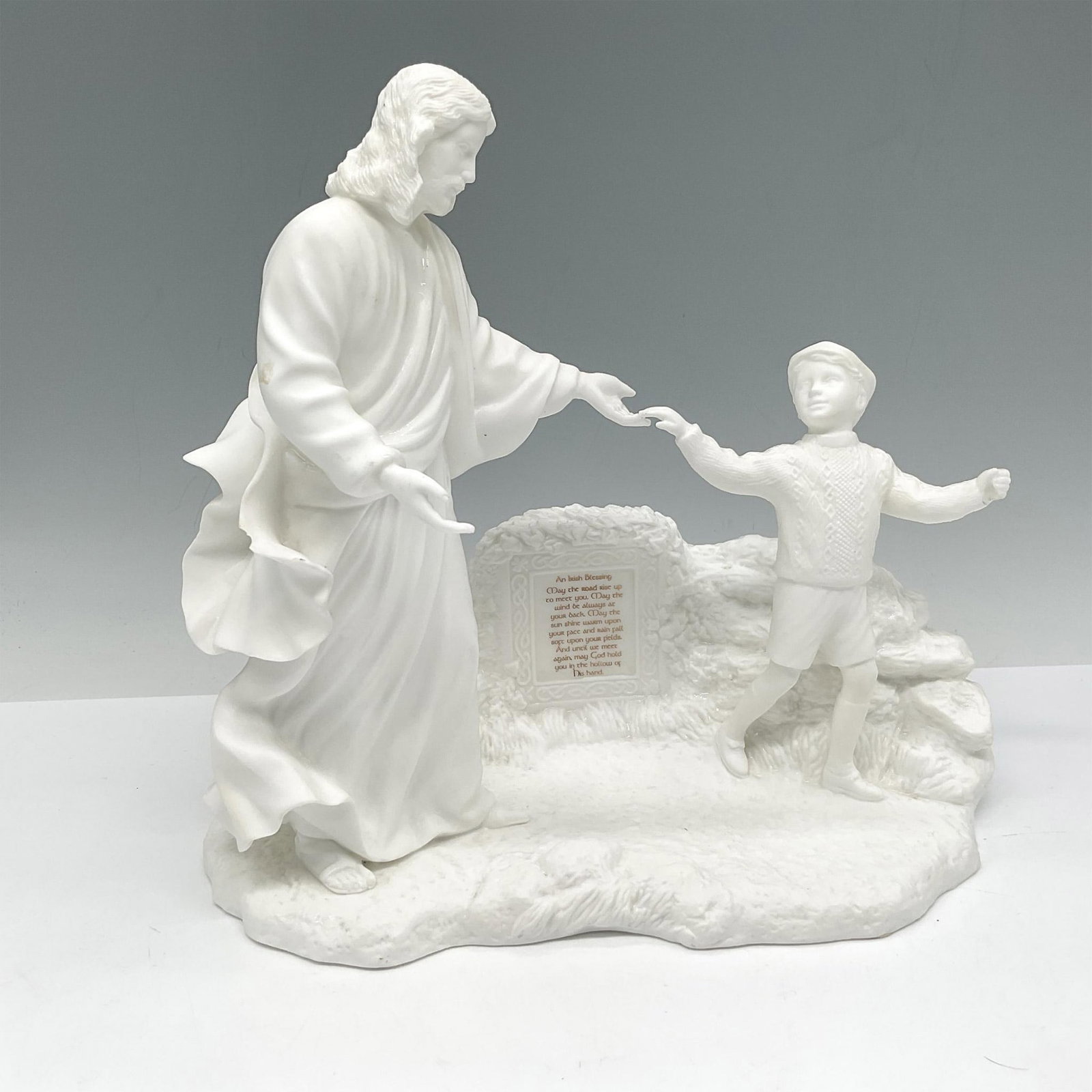 Lenox Bone China Figurine, An Irish Blessing: Jesus and boy standing, touching hands in front of Irish Blessing plaque. Lenox backstamp. Issued: 20th century Dimensions: 9.25"L x 6"W x 9.25"H Manufacturer: Lenox Country of Origin: United States
