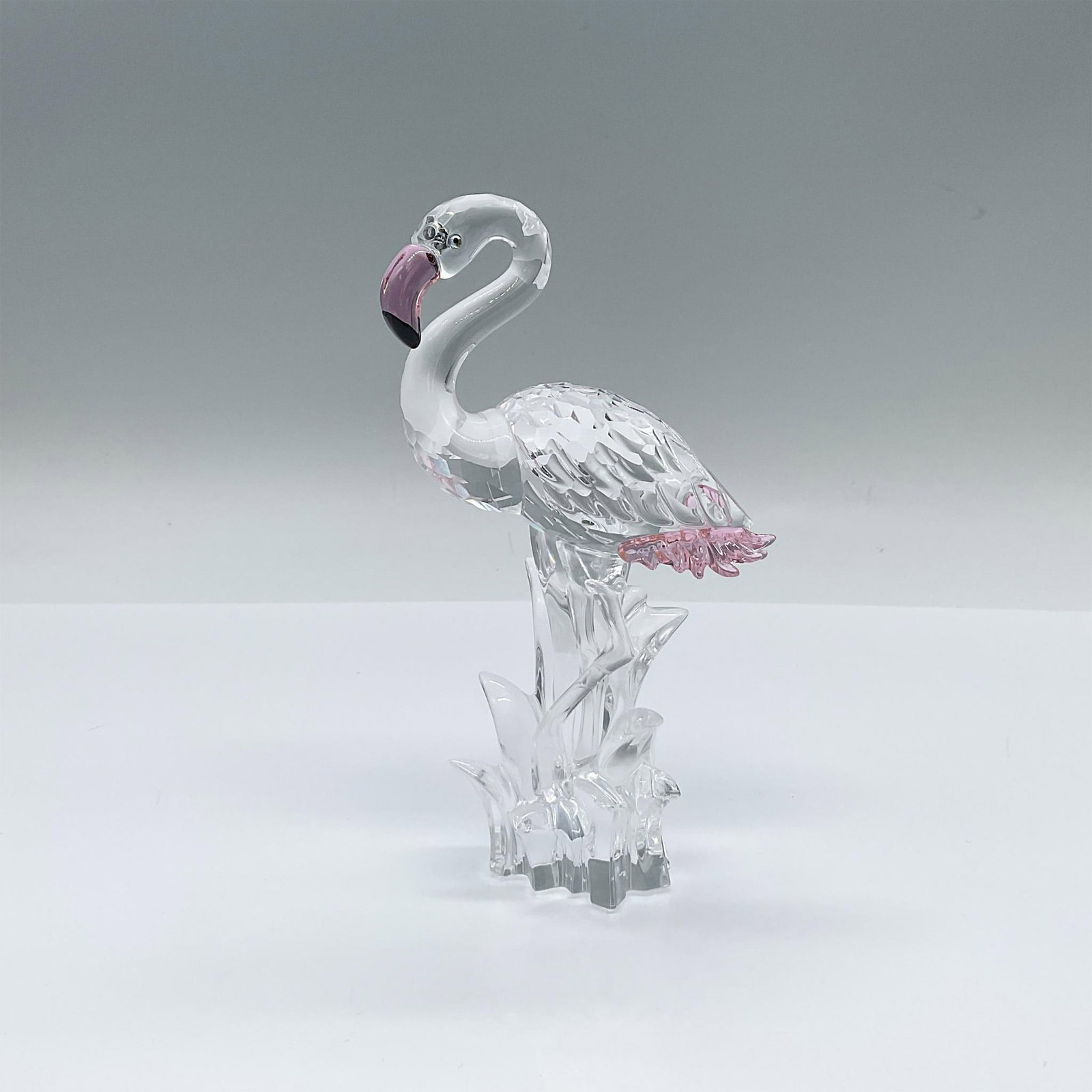 Swarovski Crystal Figurine, Flamingo: Part of the Feathered Beauties collection. A clear crystal bird accented with pink Rosaline crystal on the feathers and beak. Swarovski marked. Artist: Gabriele Stamey Issued: 2002-2011 Dimensions: 3.