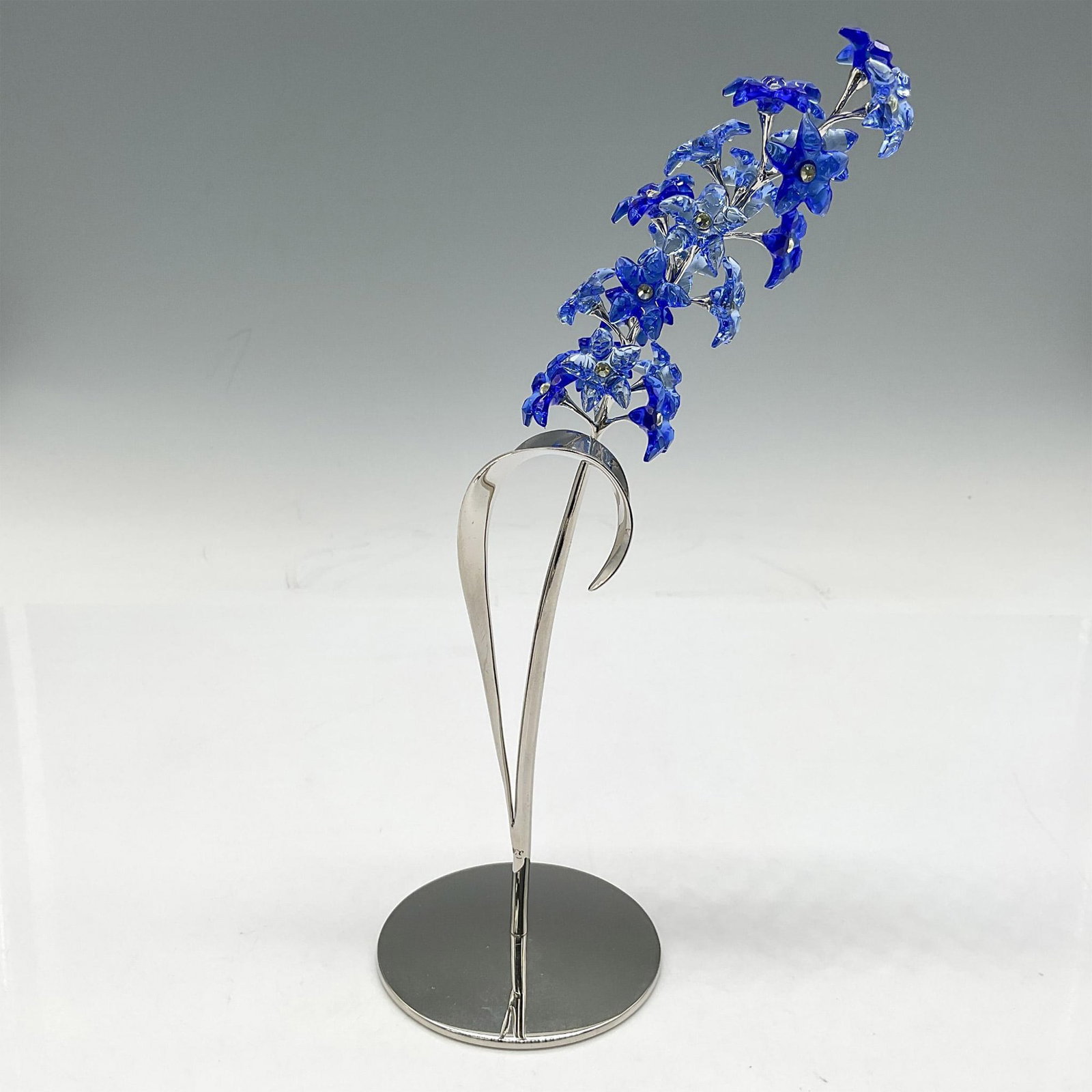 Swarovski Crystal Figurine, Paradise Flowers - Dindori: Part of the Exotic Flowers collection, the beautiful simplicity of the design in sapphire crystal set on rhodium stand with leaf. Swarovski impressed mark. 9601 040 201. Artist: Yasmine Hurel Issued: 