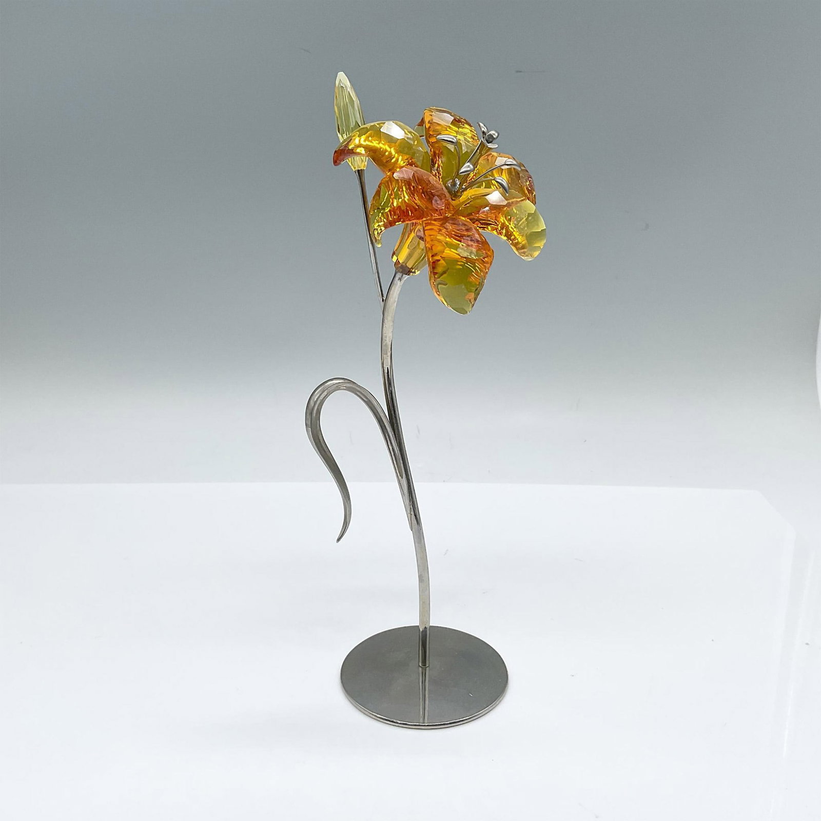 Swarovski Crystal Paradise Flowers Figurine, Dillia Topaz: Part of the Exotic Flowers collection. A beautiful tiger lily with topaz petals and silver-tone metal stamen. The bloomed blossom is on a metal stem and leaf. Swarovski impressed stamp on the stem. Th