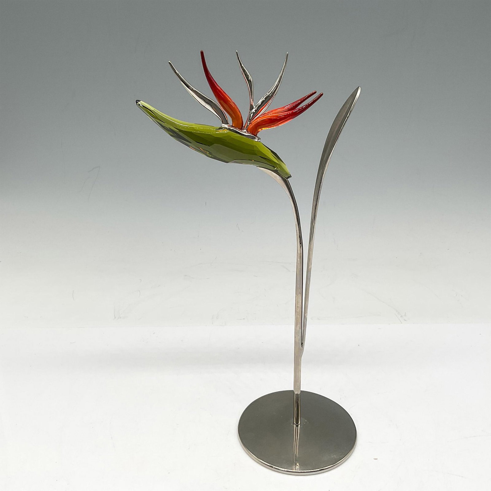 Swarovski Silver Crystal Figurine, Dalmally Tropic Sun: This beautiful figural is part of the Exotic Flowers Collection with its rhodium stem and stand to its' vibrant green and fire orange crystal this is a stunning addition to any home. Swarovski backsta