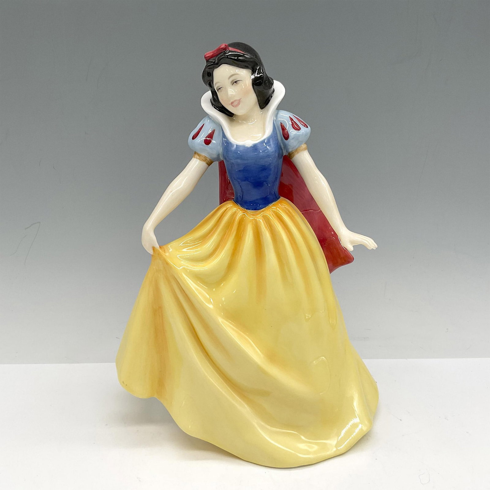 Snow White - HN3678 - Royal Doulton Figurine: Artist: Pauline Parsons Issued: 1995 Dimensions: 8.25"H Edition Number: 1807 Manufacturer: Royal Doulton Country of Origin: England