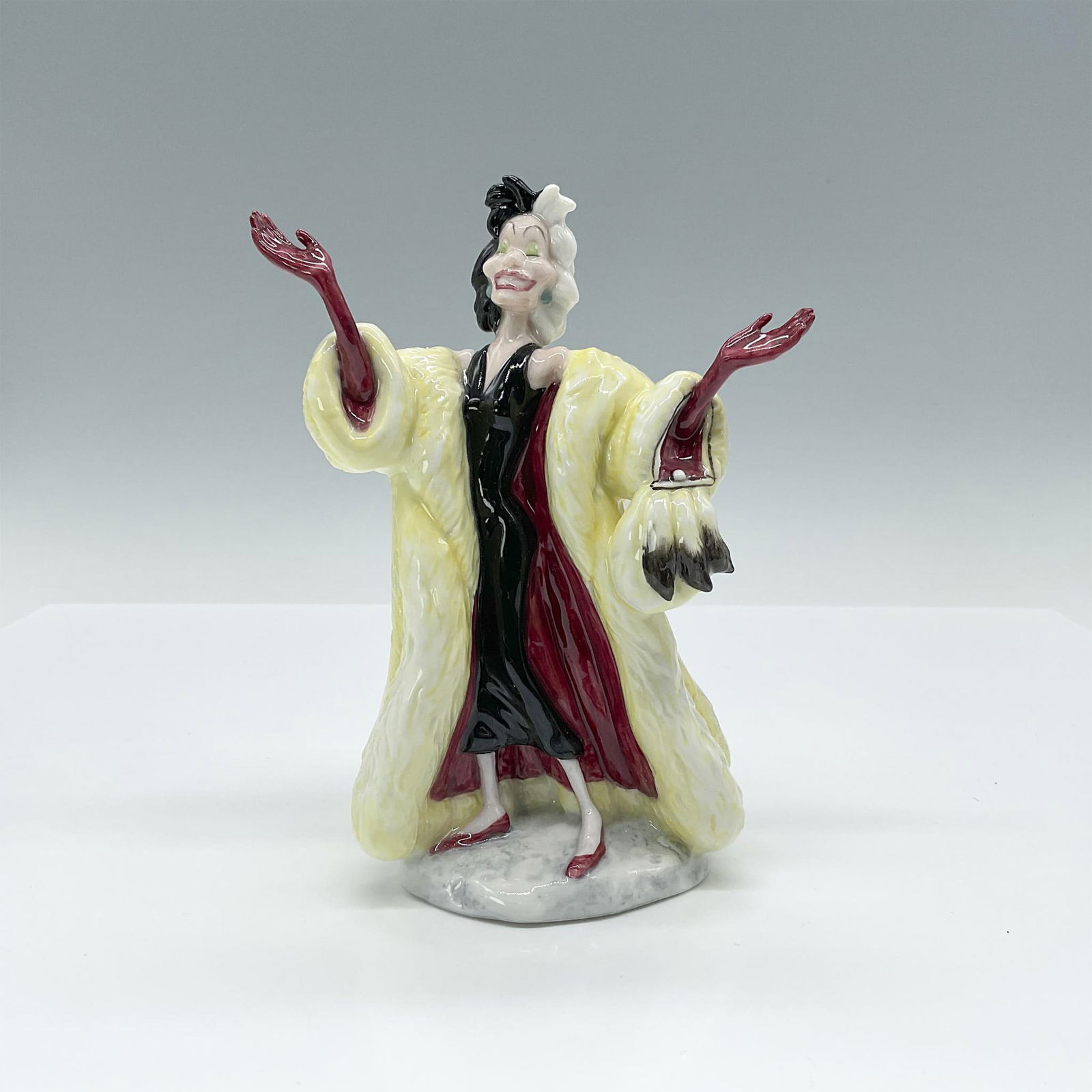 101 Dalmatians Cruella De Vil - Royal Doulton Walt Disney Figurine: Porcelain figurine depicting Cruella De Vil DM1 from the 101 Dalmatians series. Royal Doulton and Disney backstamps. Artist: Martyn Alcock Issued: 1997-2001 Dimensions: 4.25"L x 3.5"W x 6.25"H Manufac