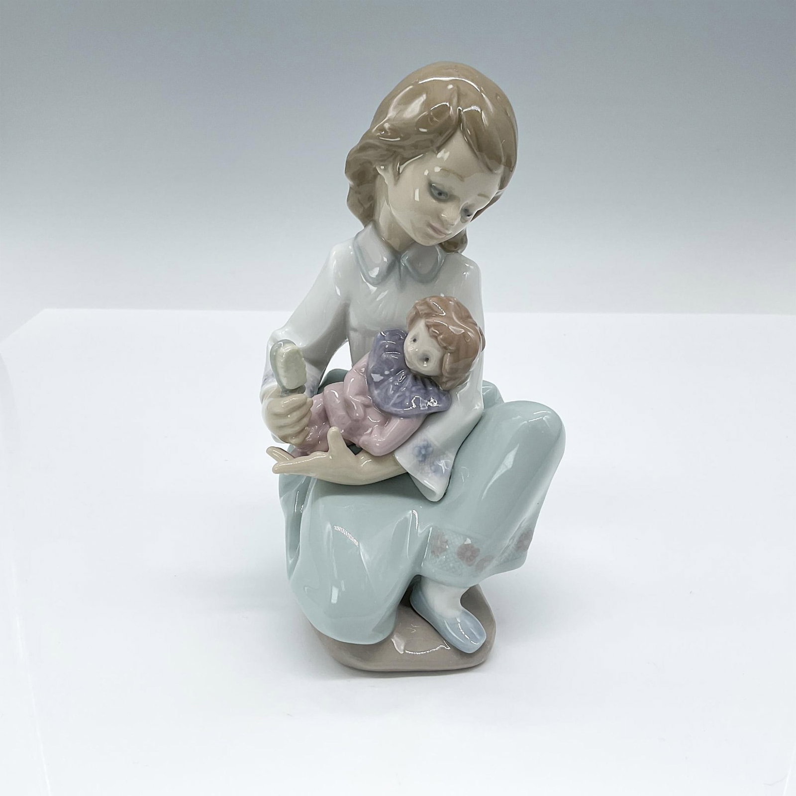 Thoughtful Caress 1005990 - Lladro Porcelain Figurine: Glossy finish; Lladro backstamp. Artist: Francisco Polope Issued: 1993 - 1996 Dimensions: 6"H Manufacturer: Lladro Country of Origin: Spain