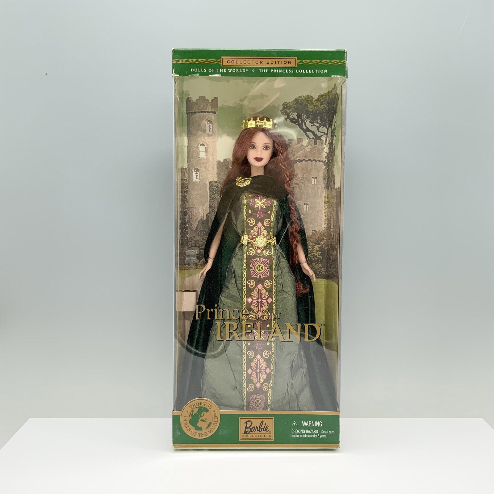 Mattel Dolls of the World Barbie, Princess of Ireland: A red-haired woman in a green Celtic dress with pink and gold patterns, elegantly draped with a matching green velvet cloak. Marked Mattel. This item has its original box. Dimensions of the box: 5.75"