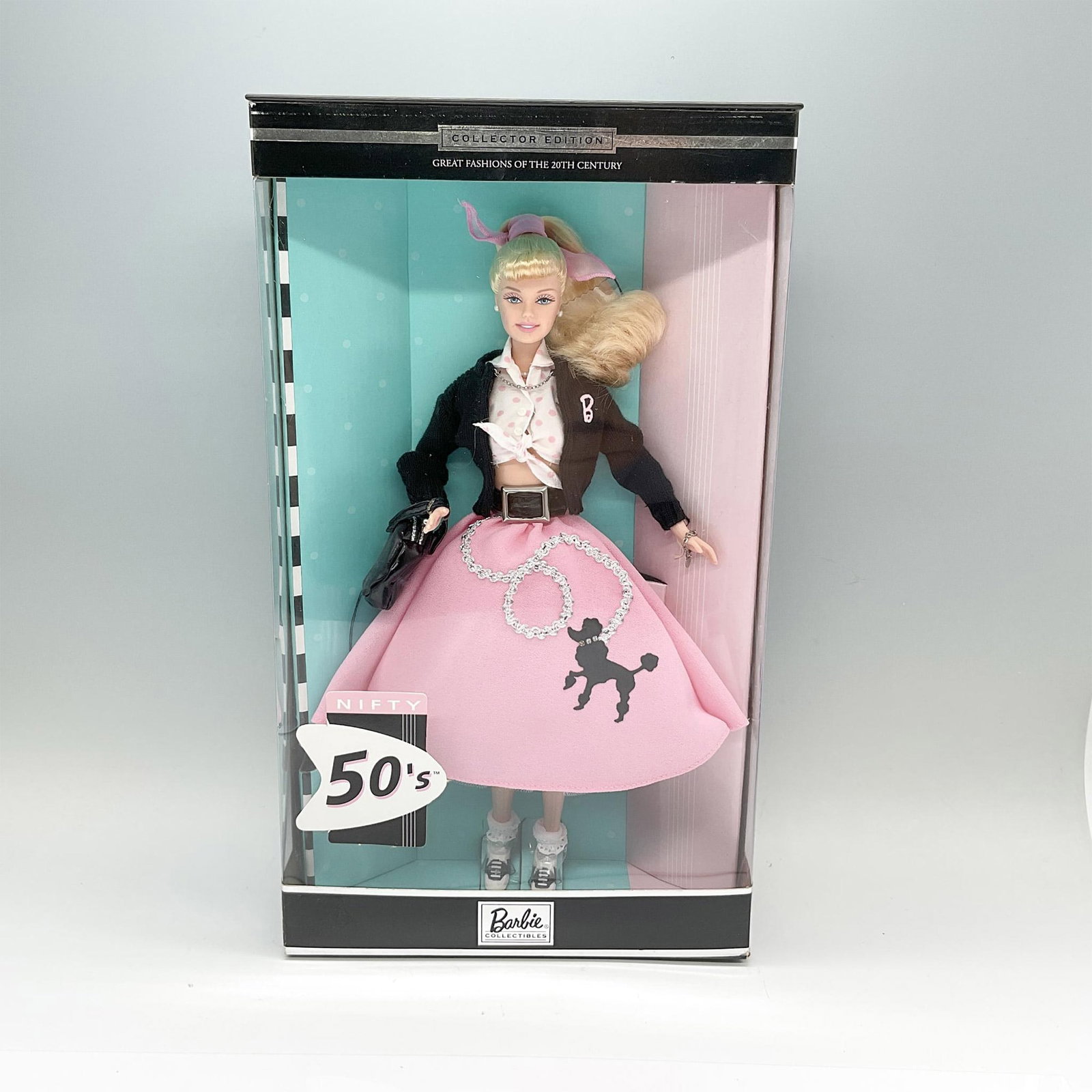 Mattel Collector Edition Barbie Doll, Nifty 50's: A Barbie Collectibles, and the fifth in the Great Fashions of the 20th Century collection. Barbie in a pale blonde hair up with in pink bow, and dressed in a pink poodle skirt with a black sweater. Sh