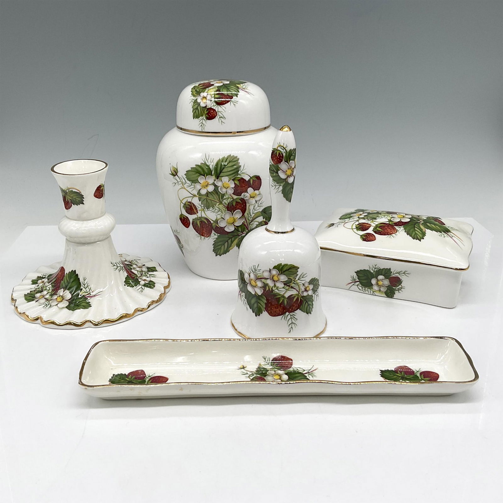 5pc Hammersley Bone China Decor Pieces, Strawberry Ripe: Colorful design of blooming strawberries. Set includes jar with lid, bell, keepsake box with lid, candlestick and pin dish. Hammersley backstamp. Issued: 20th century Dimensions: 6.25"H x 4.25" dia. M