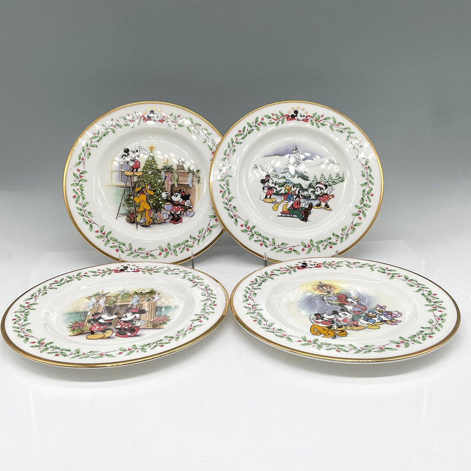 4pc Lenox Bone China Holiday Plates by Disney, Mickey & Co.: Plates included - A Carolin We Go, Under the Mistletoe, Decorating the Tree and First Snow. Lenox and Disney backstamp. Issued: 20th century Dimensions: 0.50"H x 8" dia. Manufacturer: Lenox Country of
