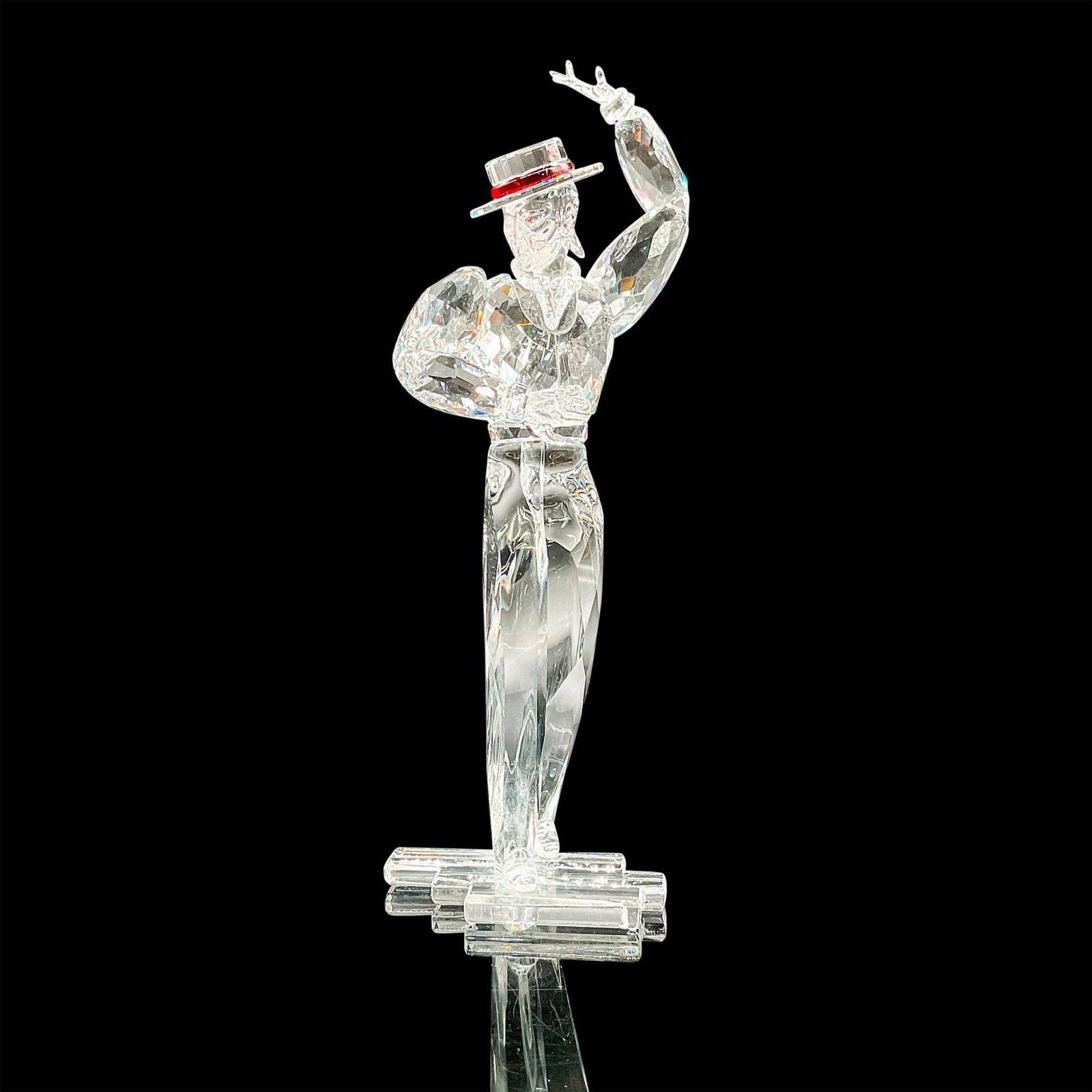 Swarovski SCS Crystal Figurine, Antonio: This Swarovski crystal item, Antonio, is part of the Magic of Dance trilogy and is made of clear crystal. The ribbon of his hat is made of red crystal. Swarovski etched backstamp. Issued: 2003 Dimensi