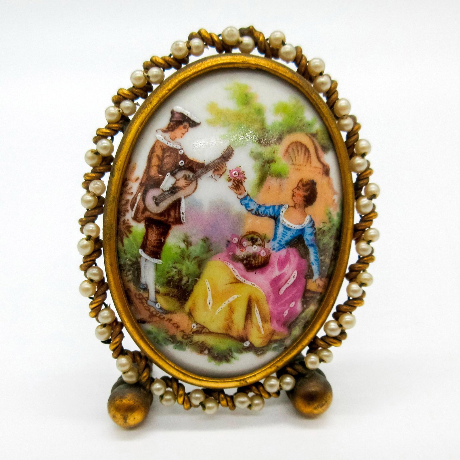 Olletsac Cromos de Limoges Mini Plaque, Serenading Couple: A beautiful acrylic oval plaque with a painted scene of a man serenading to his love. Plaque encased in a gold-painted beaded frame. Olletsac Cromos de Limoges backstamp. Artist signature on the botto
