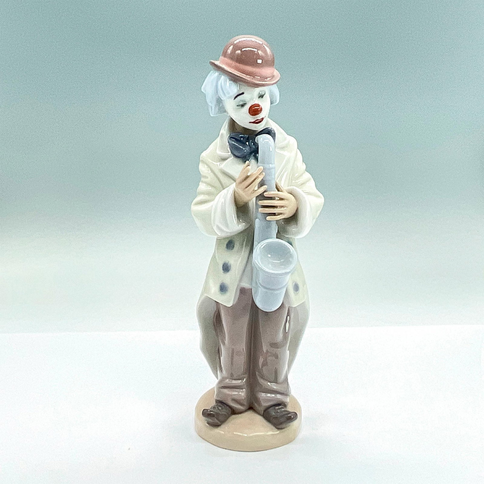 Sad Sax 1005471 - Lladro Porcelain Figurine: Glossy finish; Lladro backstamp. Artist: Francisco Catala Issued: 1988 - 2018 Dimensions: 8.75"H x 2.75"W Manufacturer: Lladro Country of Origin: Spain