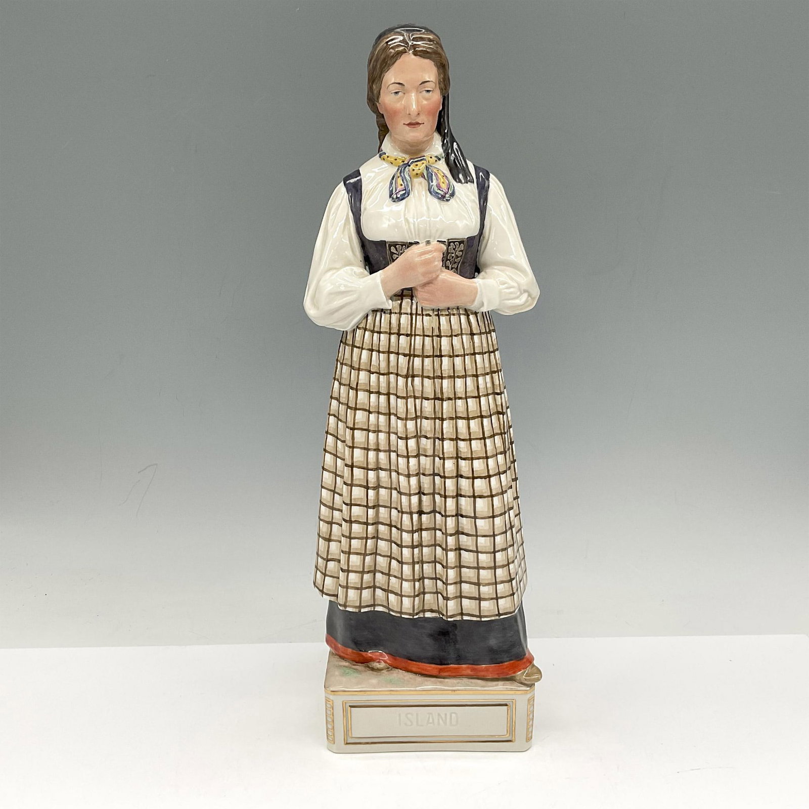 Royal Copenhagen Porcelain Figurine, Island: Danish Island woman dressed in traditional clothing of the area and period. Royal Copenhagen backstamp. 12164. Artist: Carl Martin Hansen Issued: 20th century Dimensions: 4"L x 4"W x 12.5"H Manufactur