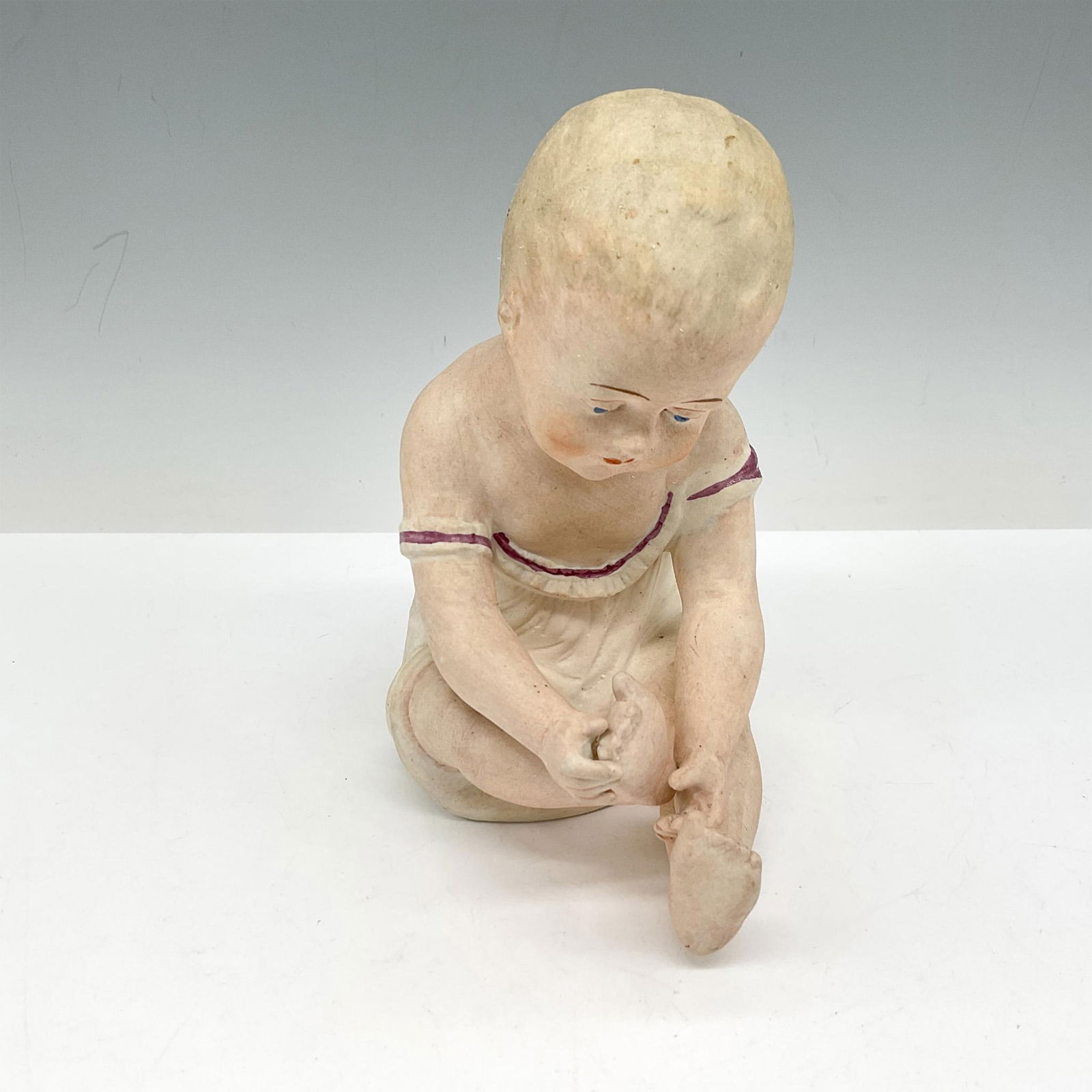 Gebruder Heubach Bisque Piano Baby, Signed: Delicately colored in pink, cream and tan. Signed. LR backstamp. Issued: c. 1944 Dimensions: 3.25"L x 4.75"W x 6"H Country of Origin: Germany