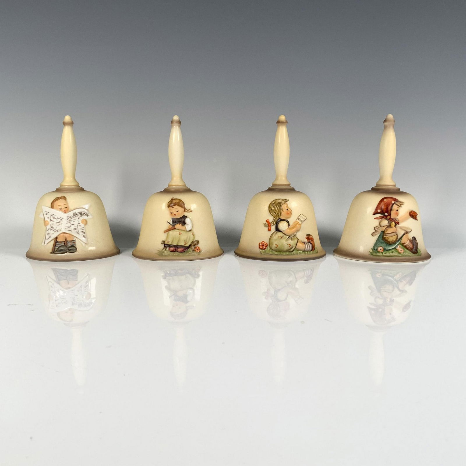4pc Goebel Hummel Annual Bells, HUM 701, 707, 710, 711: In this delightful set you'll find scenes of a girl reading (1985), a boy engrossed in a newspaper (1989), another girl taking notes (1988), and a young girl enjoying a picnic (1979). Goebel Hummel ba